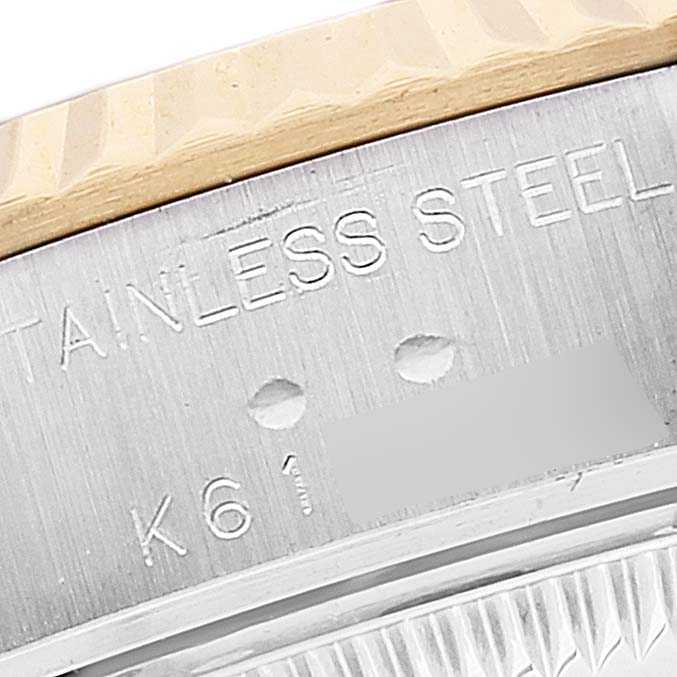 This close-up image of a Rolex Datejust 79173 Women's Steel and Gold (two tone) White Dial 79173 Women's Steel and Gold (two tone) White Dial watch shows part of the bezel and the stainless steel case with model engravings.