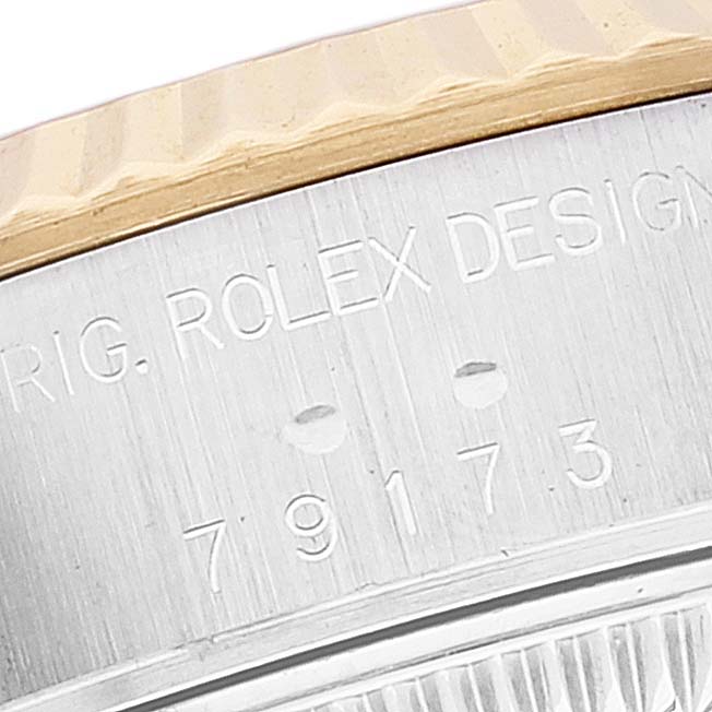 This image shows a close-up of the side of a Rolex Datejust 79173 Women's Steel and Gold (two tone) White Dial 79173 Women's Steel and Gold (two tone) White Dial watch case, highlighting the engraved serial number and fluted bezel.