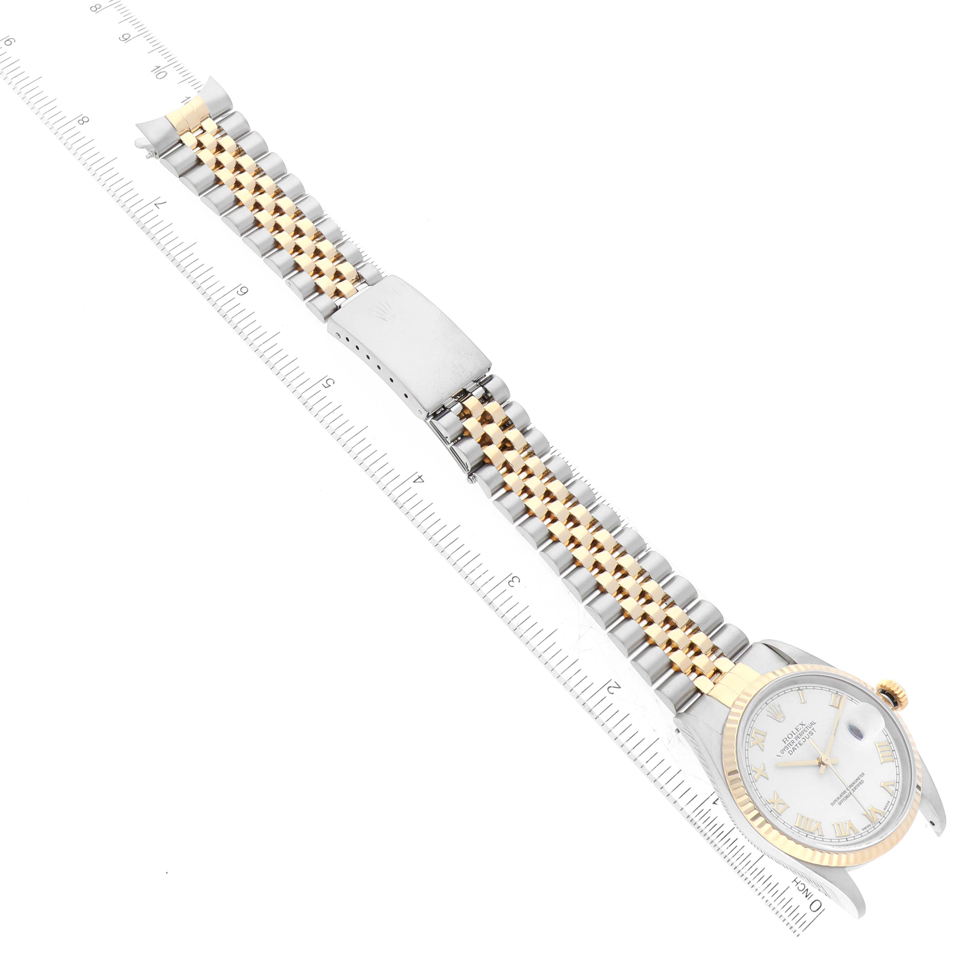 The Rolex Datejust 16233 Men's Steel and Gold (two tone) White Dial 16233 Men's Steel and Gold (two tone) White Dial watch is shown from a top-down angle, displaying the face, case, and bracelet against a ruler for scale.