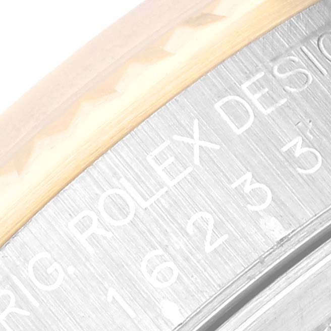 This close-up image shows part of the bezel and case back inscription of a Rolex Datejust 16233 Men's Steel and Gold (two tone) White Dial 16233 Men's Steel and Gold (two tone) White Dial watch.