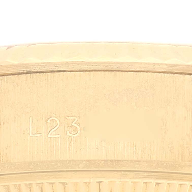 This image shows a close-up of the side of a Rolex President 69178 Women
s Yellow Gold Champagne Dial 69178 Women
s Yellow Gold Champagne Dial watch, featuring part of the bezel and engraved markings.