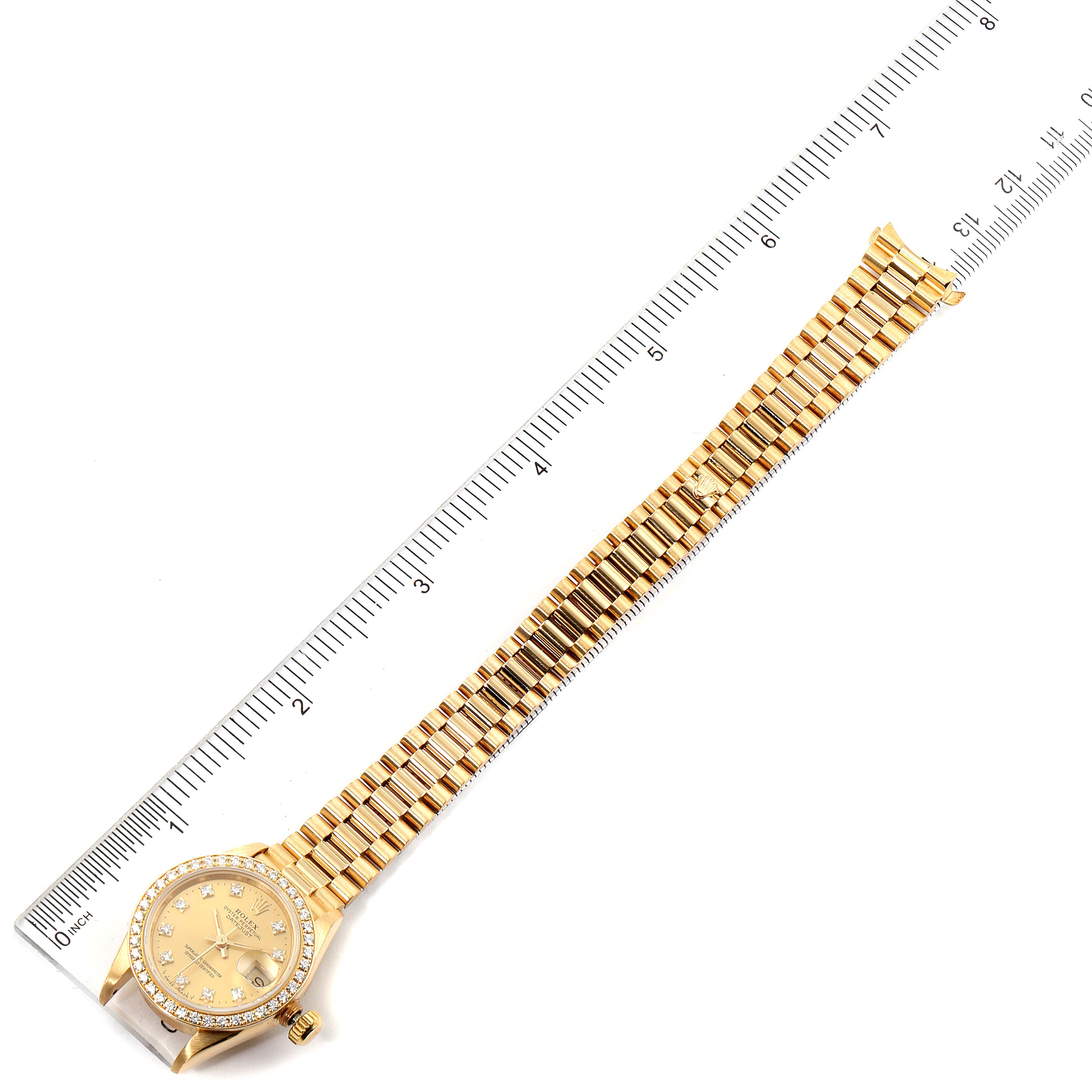 The Rolex President 69138 Women
s Yellow Gold Champagne Dial 69138 Women
s Yellow Gold Champagne Dial model watch is shown flat from above, including the face, case, and full bracelet against a ruler for measurement.