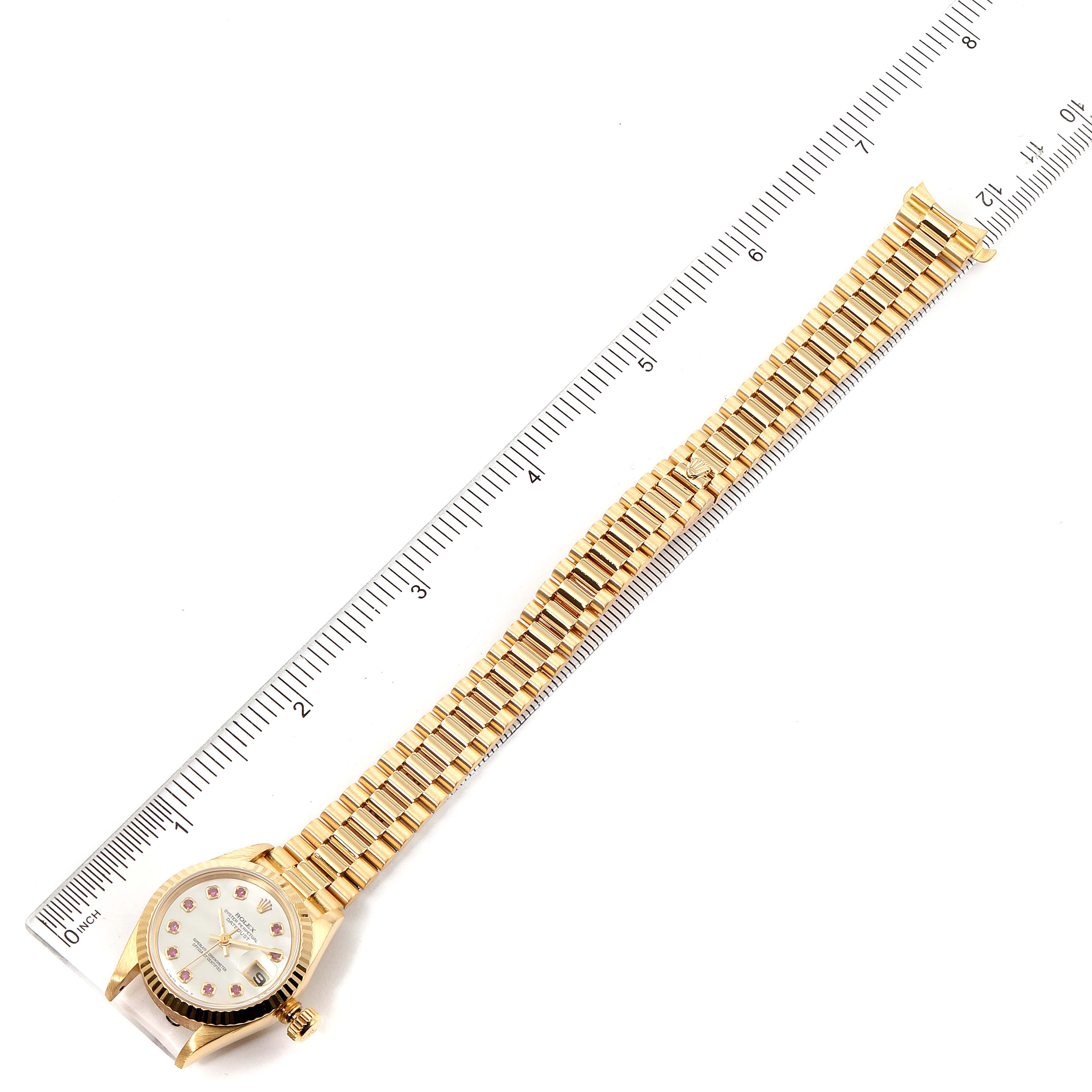 The image shows a full, top-down view of a Rolex President 69178 Women
s Yellow Gold Mother of Pearl Dial 69178 Women
s Yellow Gold Mother of Pearl Dial model watch, displaying the face, case, and bracelet alongside a measuring ruler.