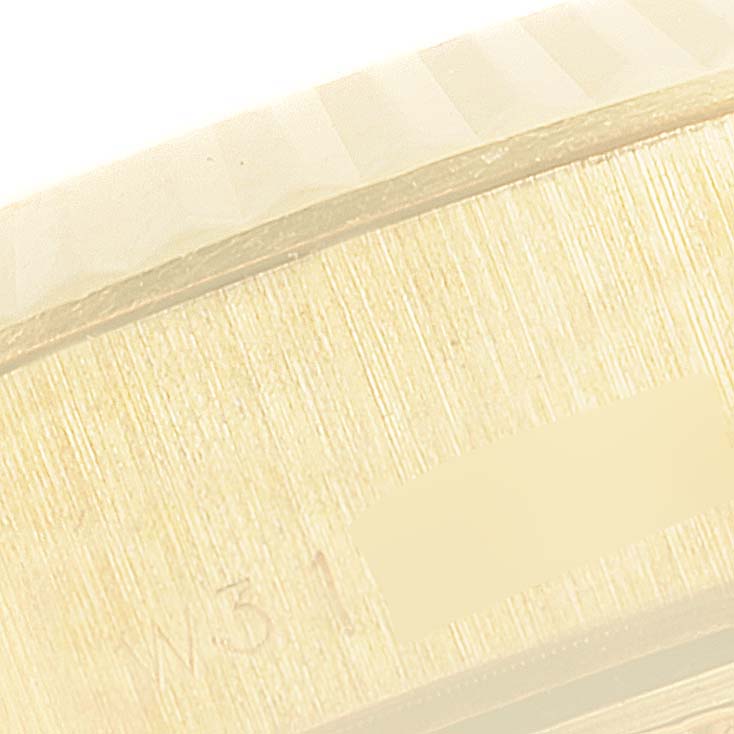 This close-up image shows part of the gold bezel and case side of a Rolex President 69178 Women
s Yellow Gold Mother of Pearl Dial 69178 Women
s Yellow Gold Mother of Pearl Dial model watch, highlighting a portion of its serial number.