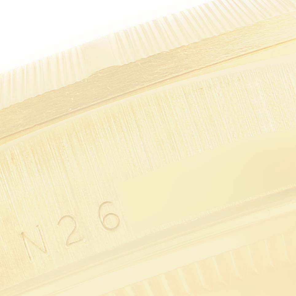 This close-up image shows the side edge and a portion of the bezel of a President model Rolex watch, focusing on the engravings.