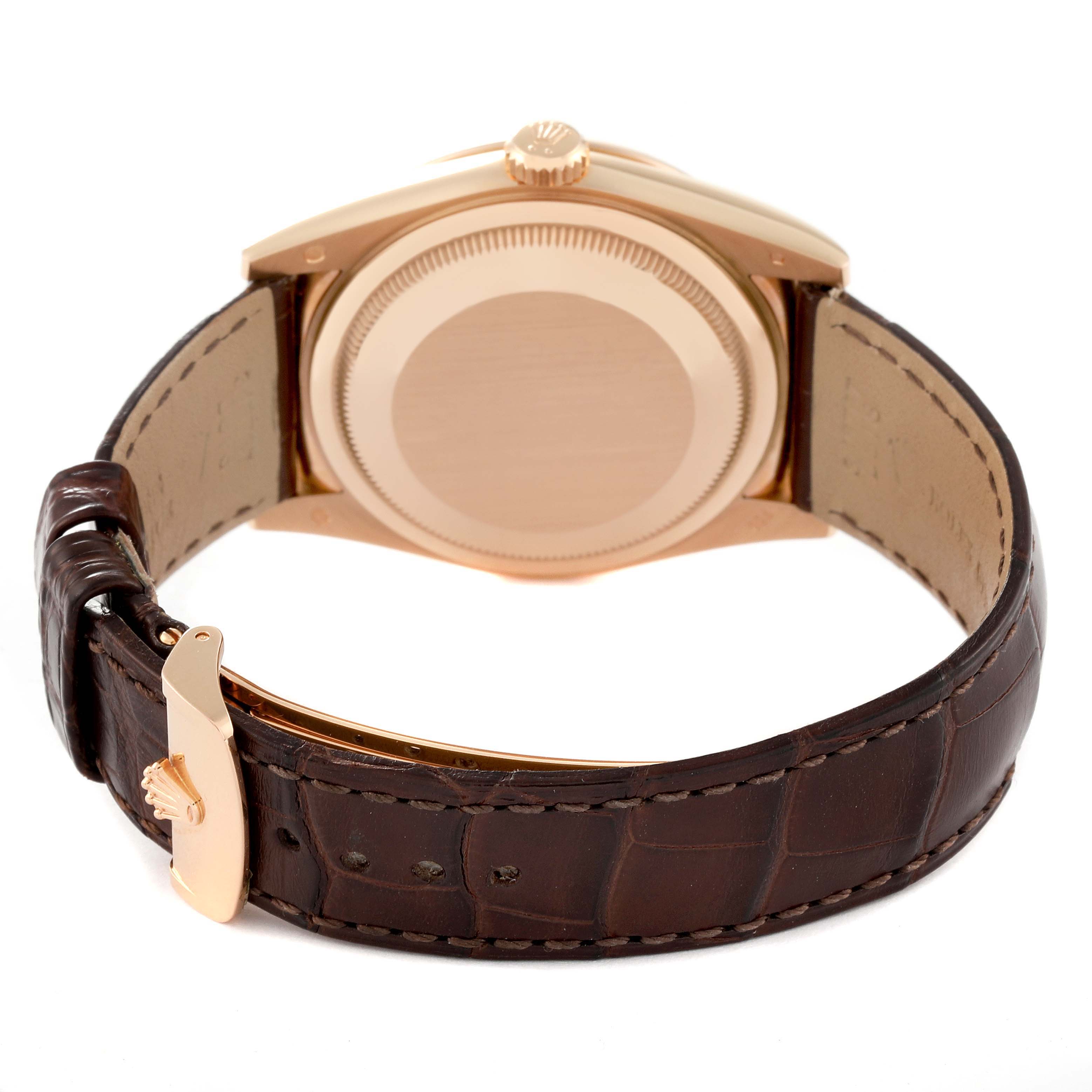 The image shows the back of a Rolex President 118135 Men's Rose Gold Brown Dial 118135 Men's Rose Gold Brown Dial model watch with a leather strap and a gold clasp.
