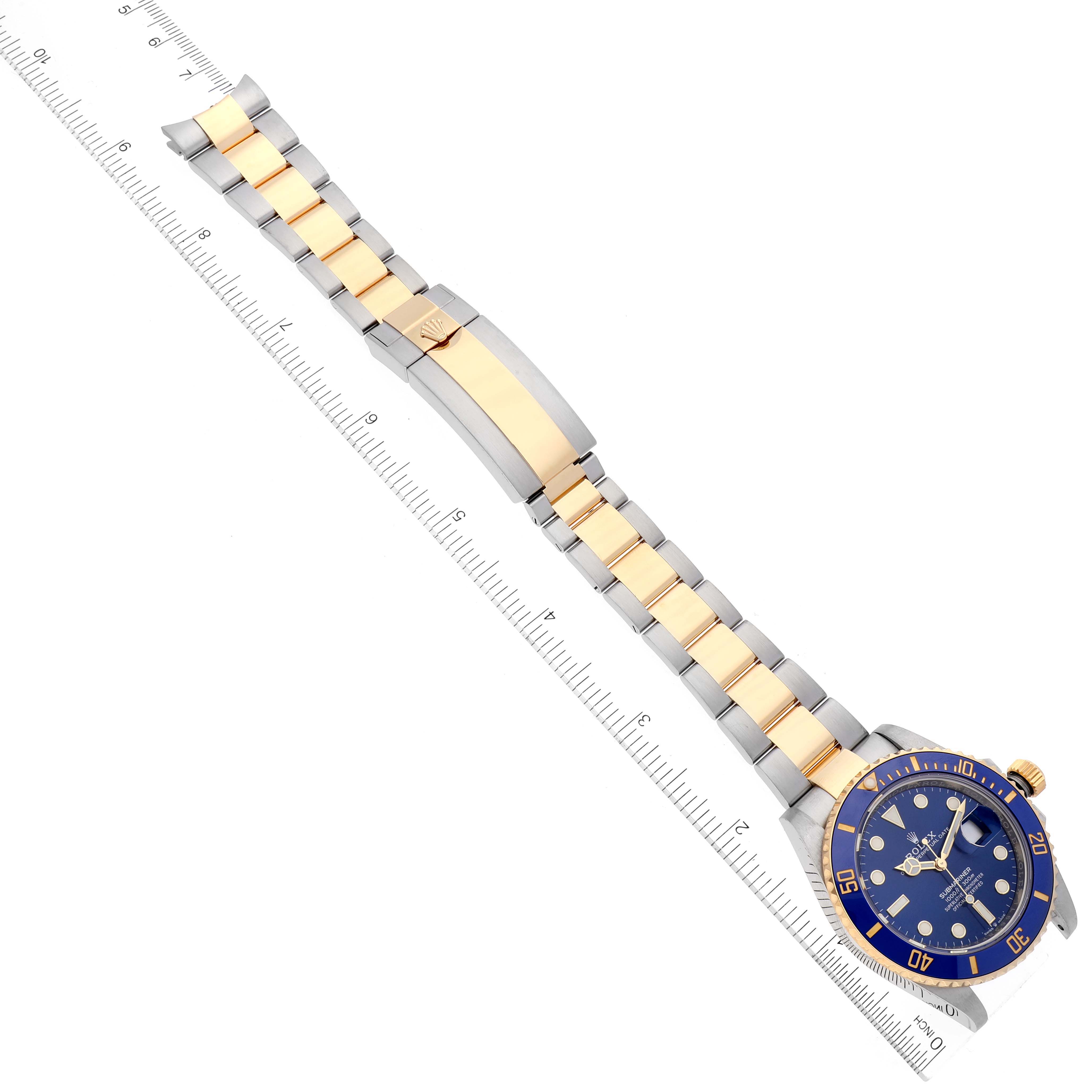 The image shows a Rolex Submariner 126613 Men's Steel and Gold (two tone) Blue Dial 126613 Men's Steel and Gold (two tone) Blue Dial watch at an angle, highlighting the band, clasp, and face.