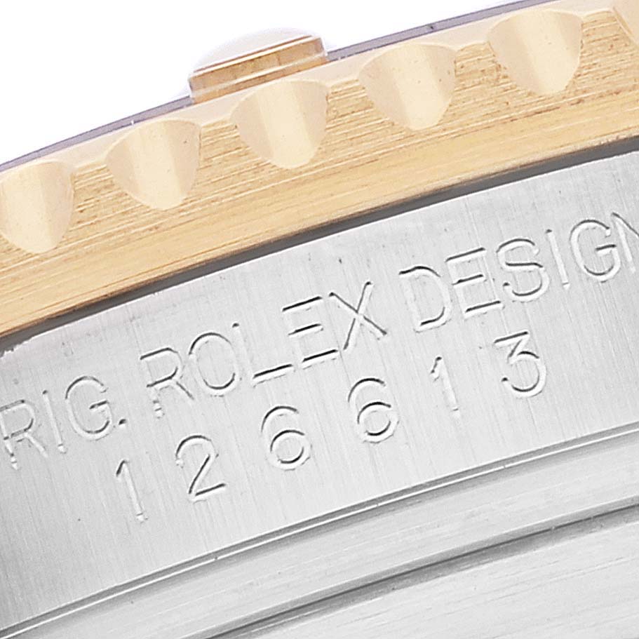 The image shows a close-up of the case back edge and part of the bezel of a Rolex Submariner 126613 Men's Steel and Gold (two tone) Blue Dial 126613 Men's Steel and Gold (two tone) Blue Dial model, revealing the engraved serial number and design details.