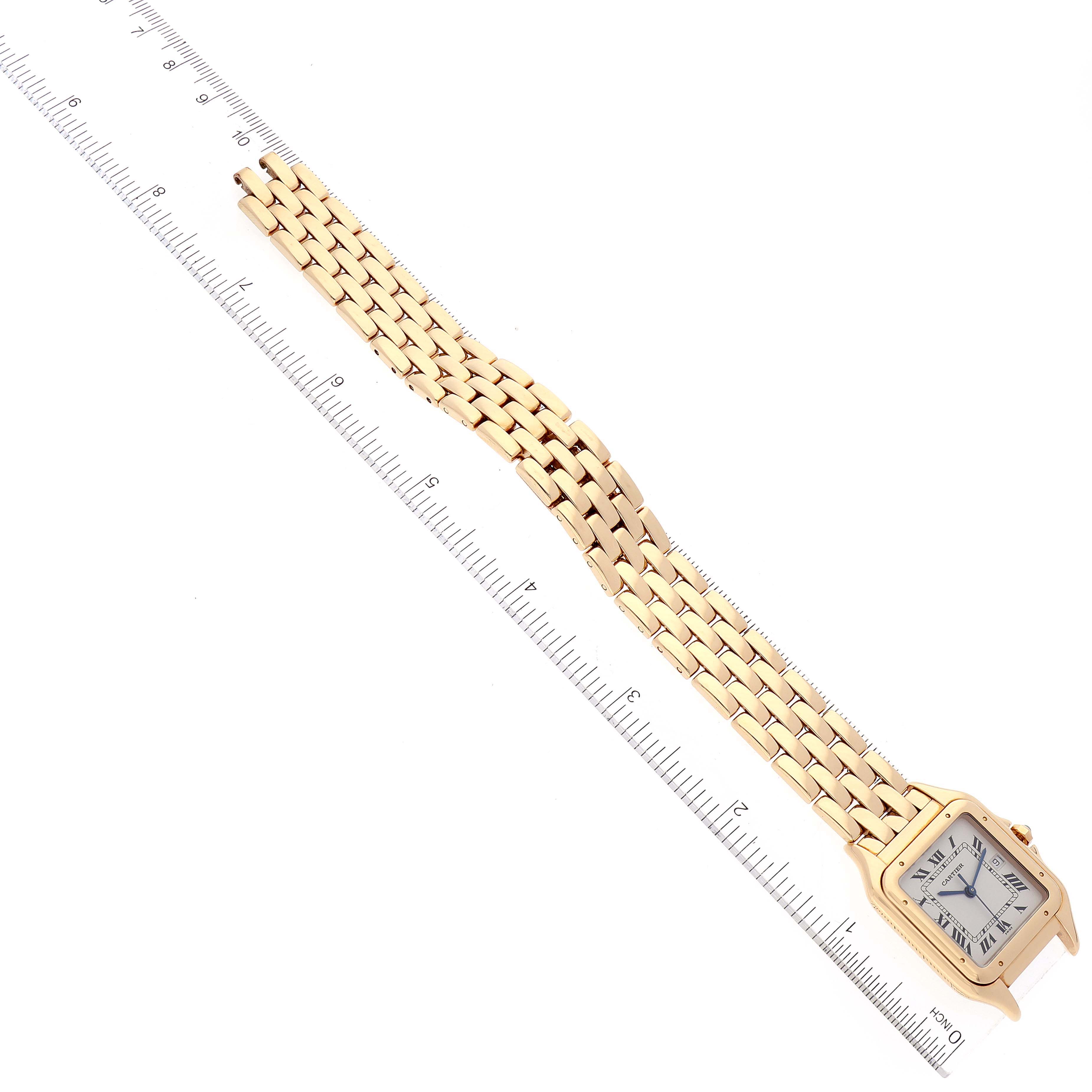 The image shows a Cartier Panthere W25014B9 Women's Yellow Gold Silver Dial W25014B9 Women's Yellow Gold Silver Dial watch laid flat against a ruler, highlighting its gold bracelet and square face with Roman numerals.