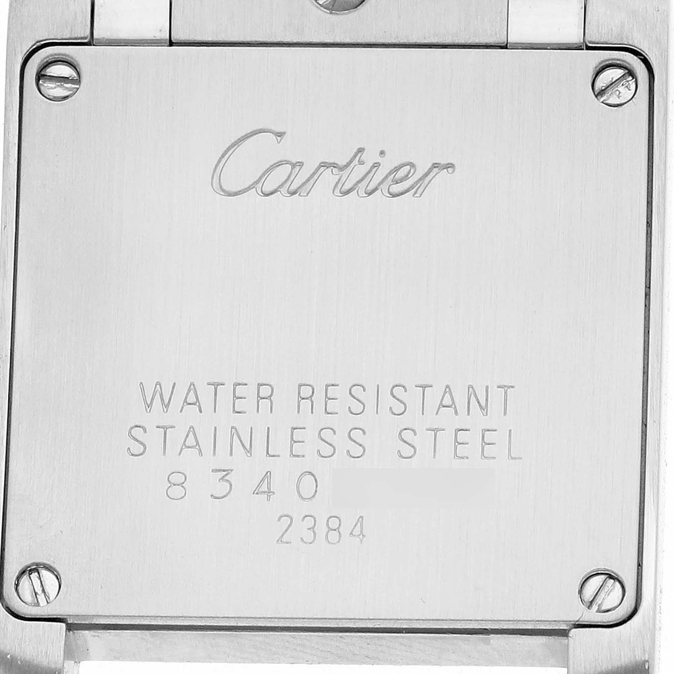 This is a close-up of the back case of a Cartier Tank Française watch, showing engravings and screws.