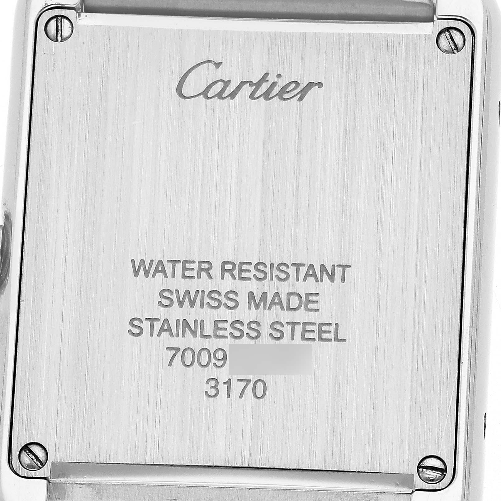 The image shows the back of a Cartier Tank Solo W5200013 Men's Stainless Steel Silver Dial watch with engravings and screws visible.