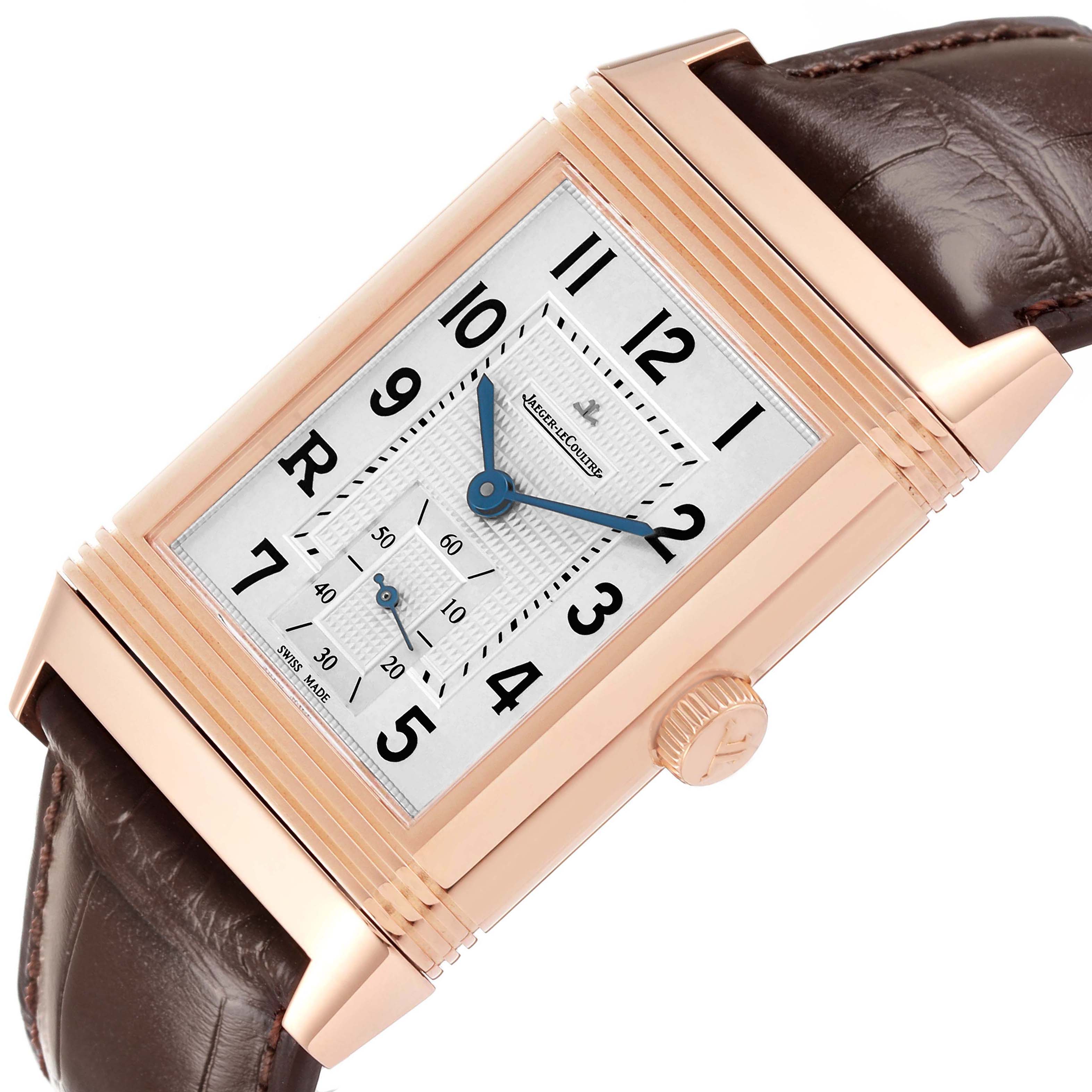 The Jaeger-LeCoultre Reverso watch is shown at a slight angle highlighting the rectangular face, crown, and leather strap.