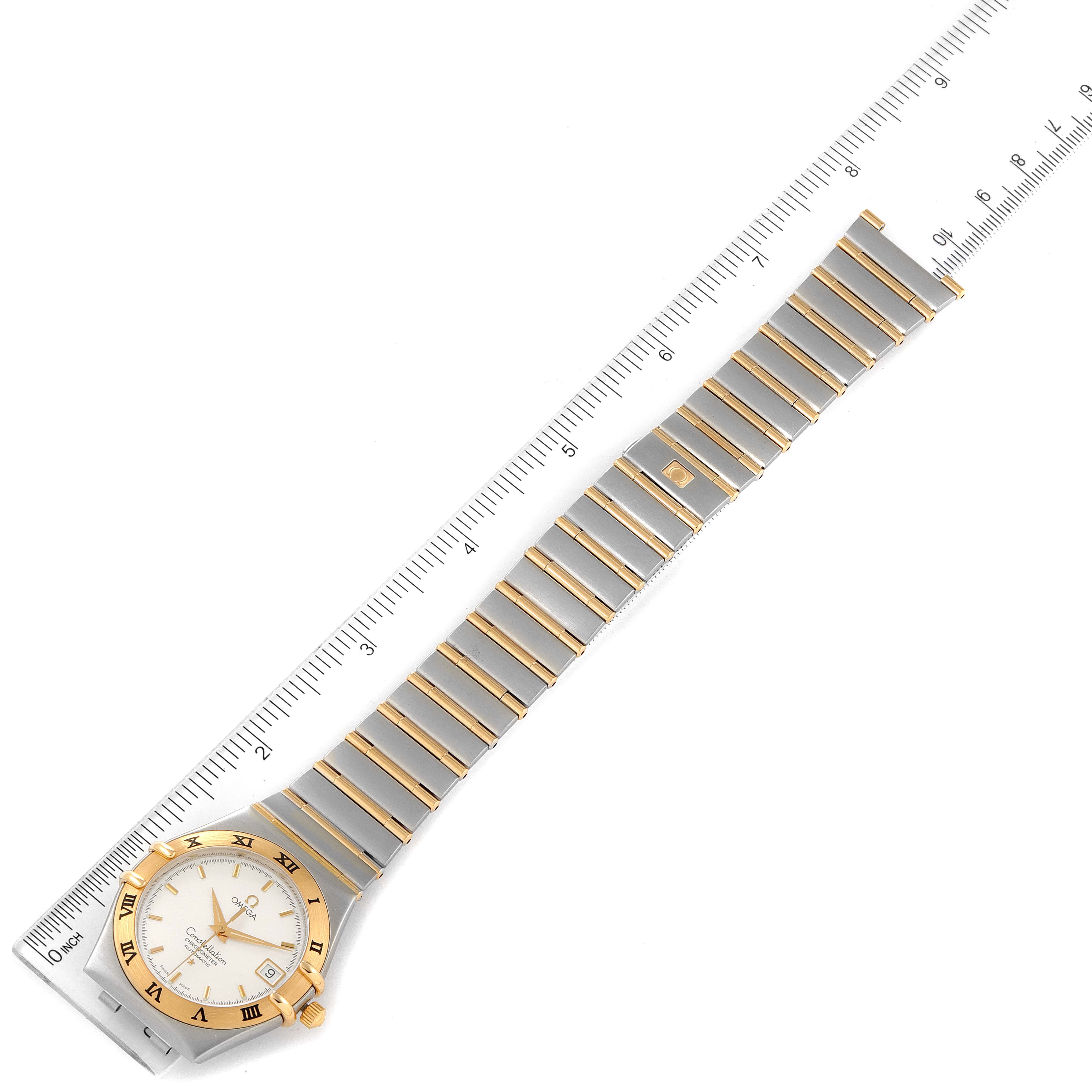 The Omega Constellation 1202.30.00 Men's Steel and Gold (two tone) Silver Dial 1202.30.00 Men's Steel and Gold (two tone) Silver Dial watch is shown from a top-down angle with the full band and face visible next to a ruler for scale.
