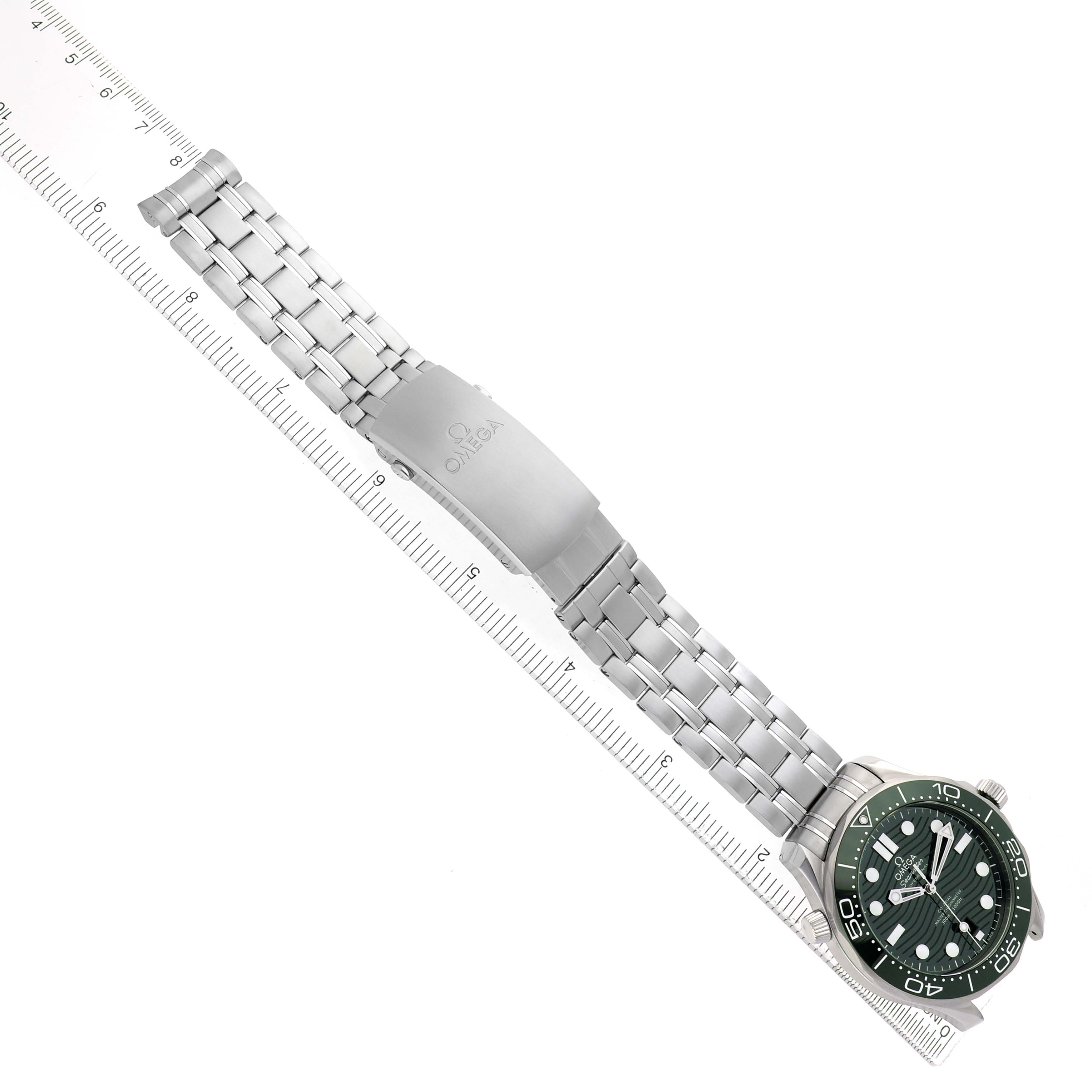 The Omega Seamaster 210.30.42.20.10.001 Men's Stainless Steel Green Dial watch is displayed from a top-down angle, showing the full watch, green dial, and bracelet on a ruler.