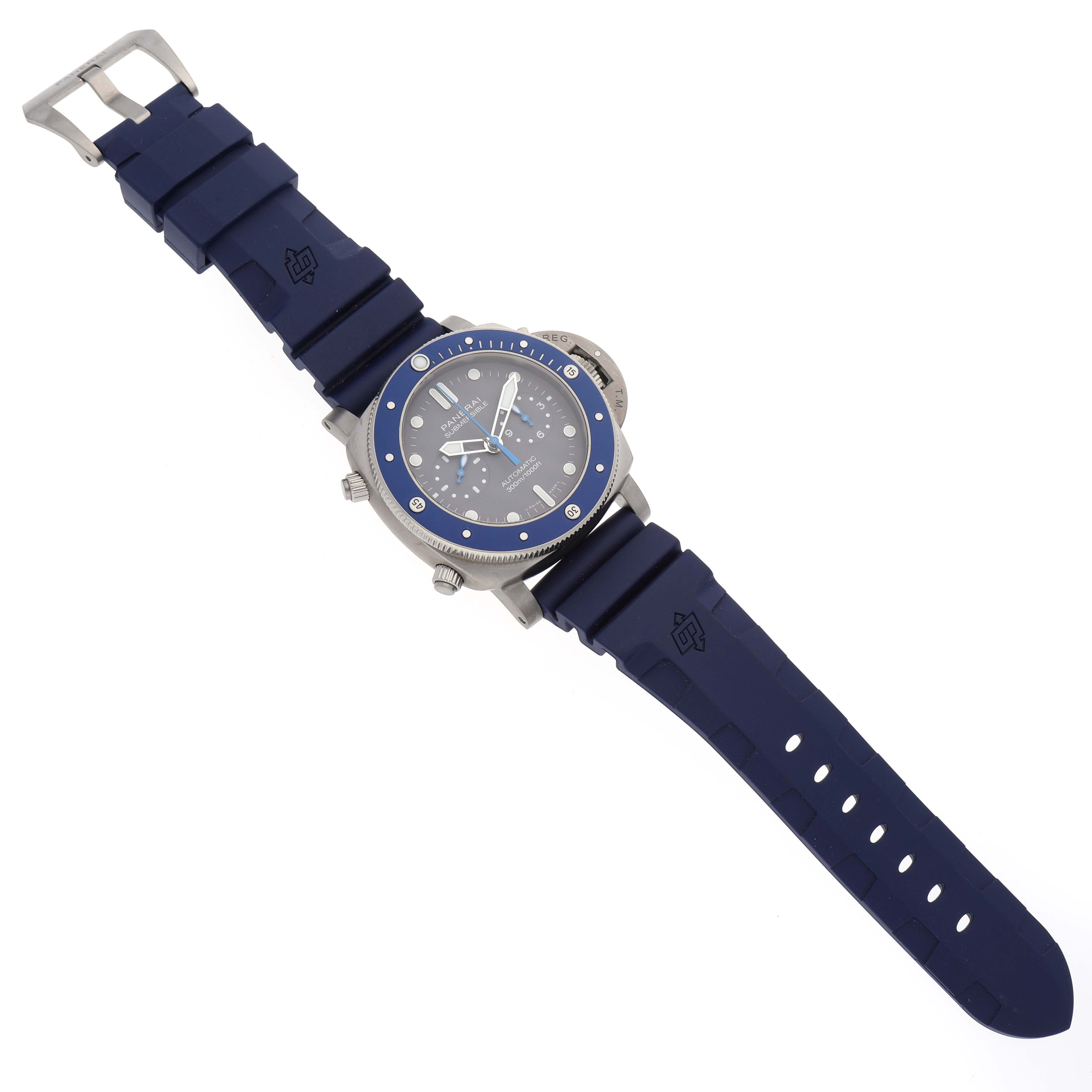 The Panerai Submersible PAM00982 Men's Titanium Grey Dial PAM00982 Men's Titanium Grey Dial watch is shown from a top-down angle, displaying the face, bezel, crown, and blue rubber strap.