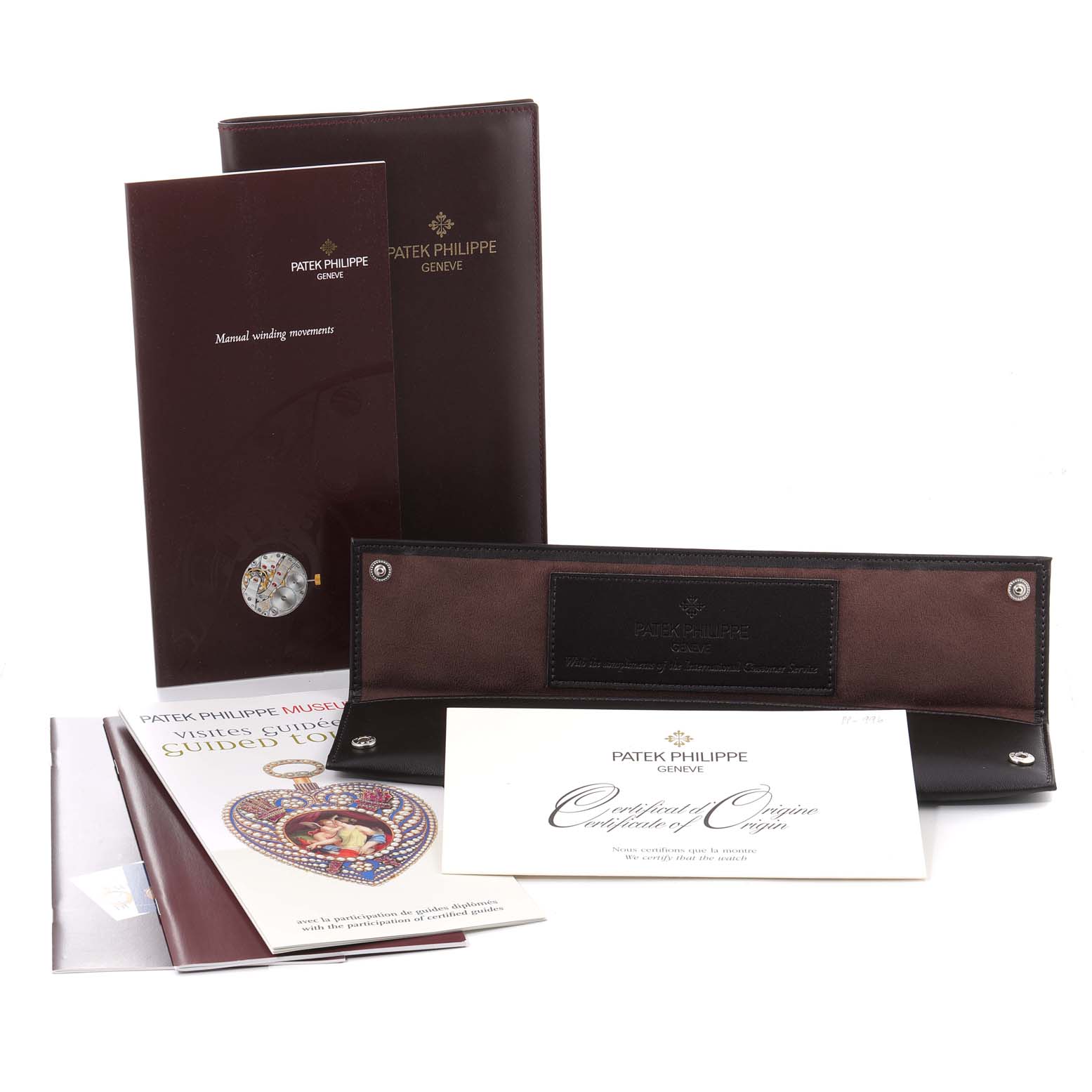 The image shows the accessories and documentation for the Patek Philippe Calatrava 5115J Men's Yellow Gold White Dial 5115J Men's Yellow Gold White Dial model.