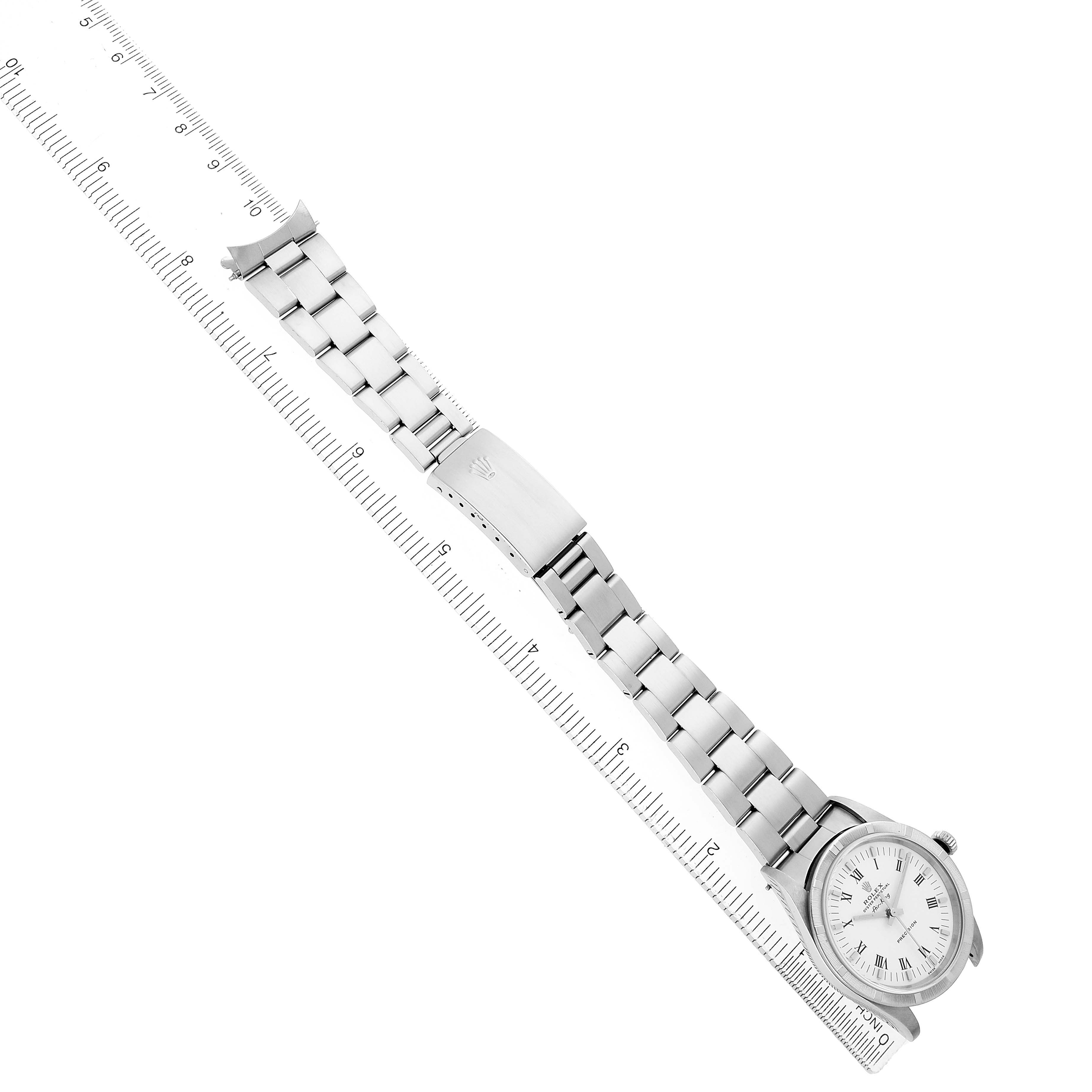 The Rolex Air-King 14010 Men's Stainless Steel White Dial watch is shown at an angle displaying the face, bezel, bracelet, clasp, and crown along with a ruler.