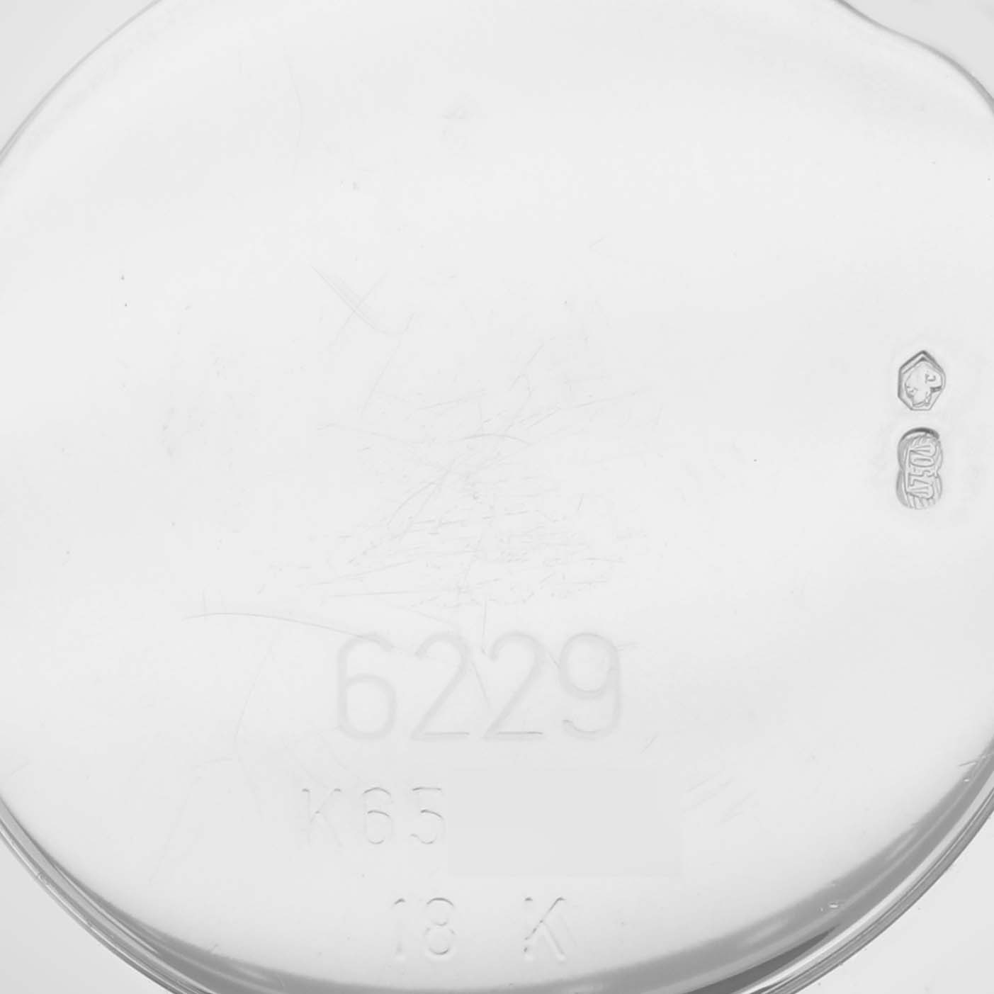 The image shows the back case of a Rolex Cellini 6229 Women's White Gold White Dial 6229 Women's White Gold White Dial watch, focusing on its engravings and stamps.