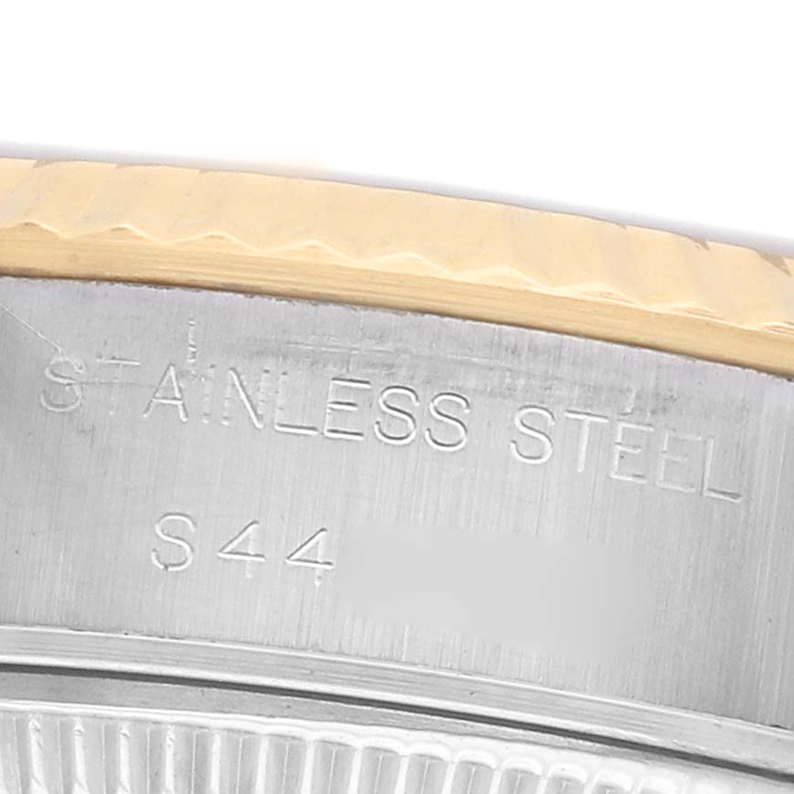 The image shows a close-up of the Rolex Datejust 69173 Women's Steel and Gold (two tone) Red Dial model case, highlighting the fluted bezel and "STAINLESS STEEL" engraving.