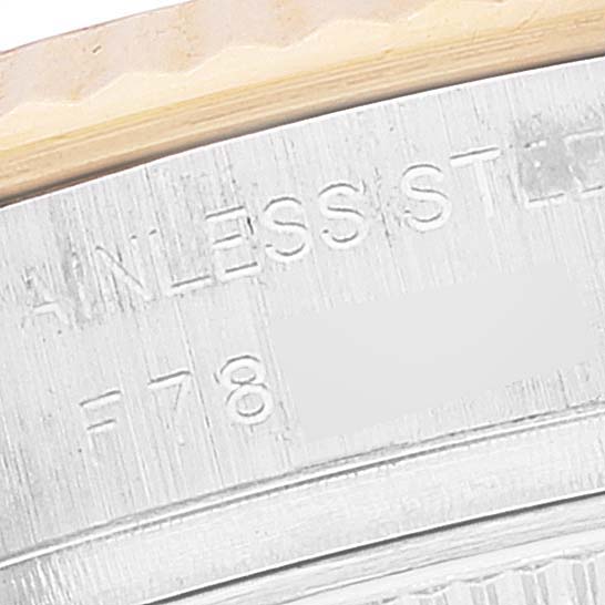 This is a close-up image of the stainless steel case back edge of a Rolex Datejust 179173 Women's Steel and Gold (two tone) Silver Dial 179173 Women's Steel and Gold (two tone) Silver Dial watch, showing part of its engraved text.