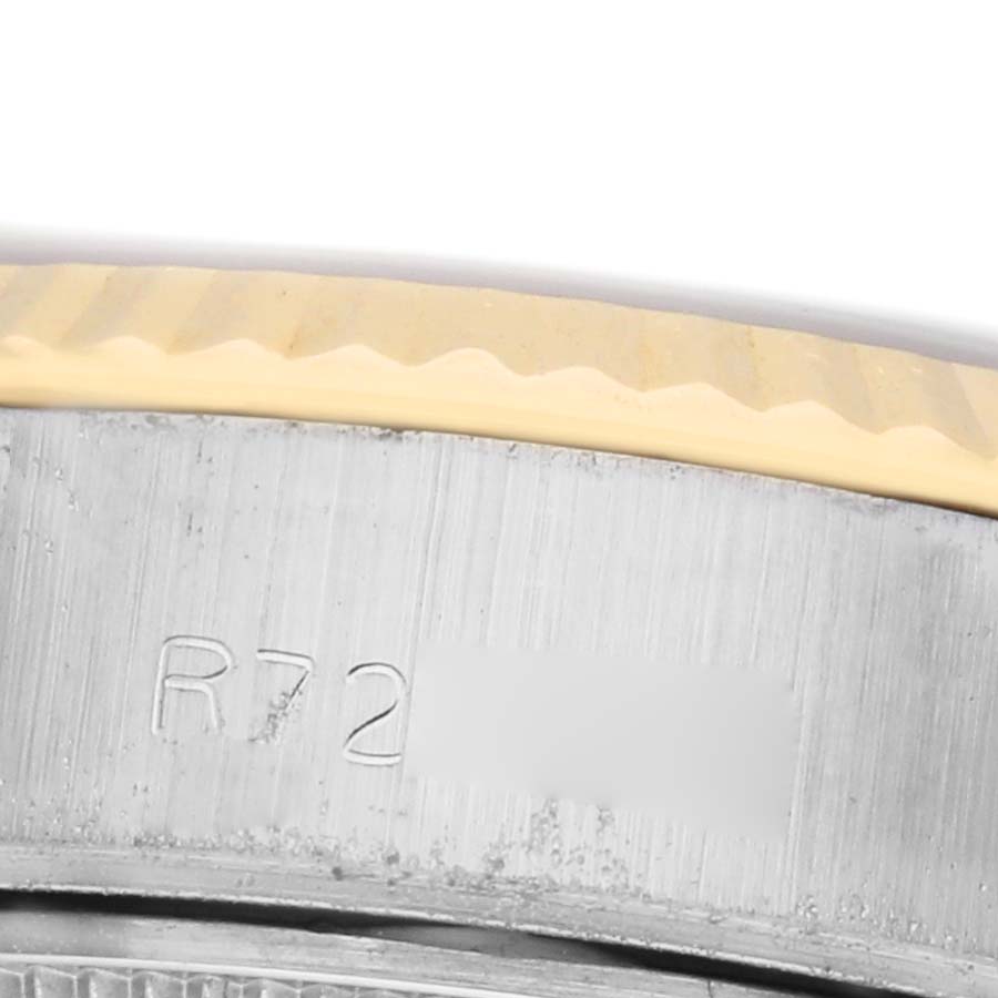 This close-up image shows the side view of a Rolex Datejust 69173 Women's Steel and Gold (two tone) Champagne Dial, focusing on the fluted bezel and part of the case with some engraving.