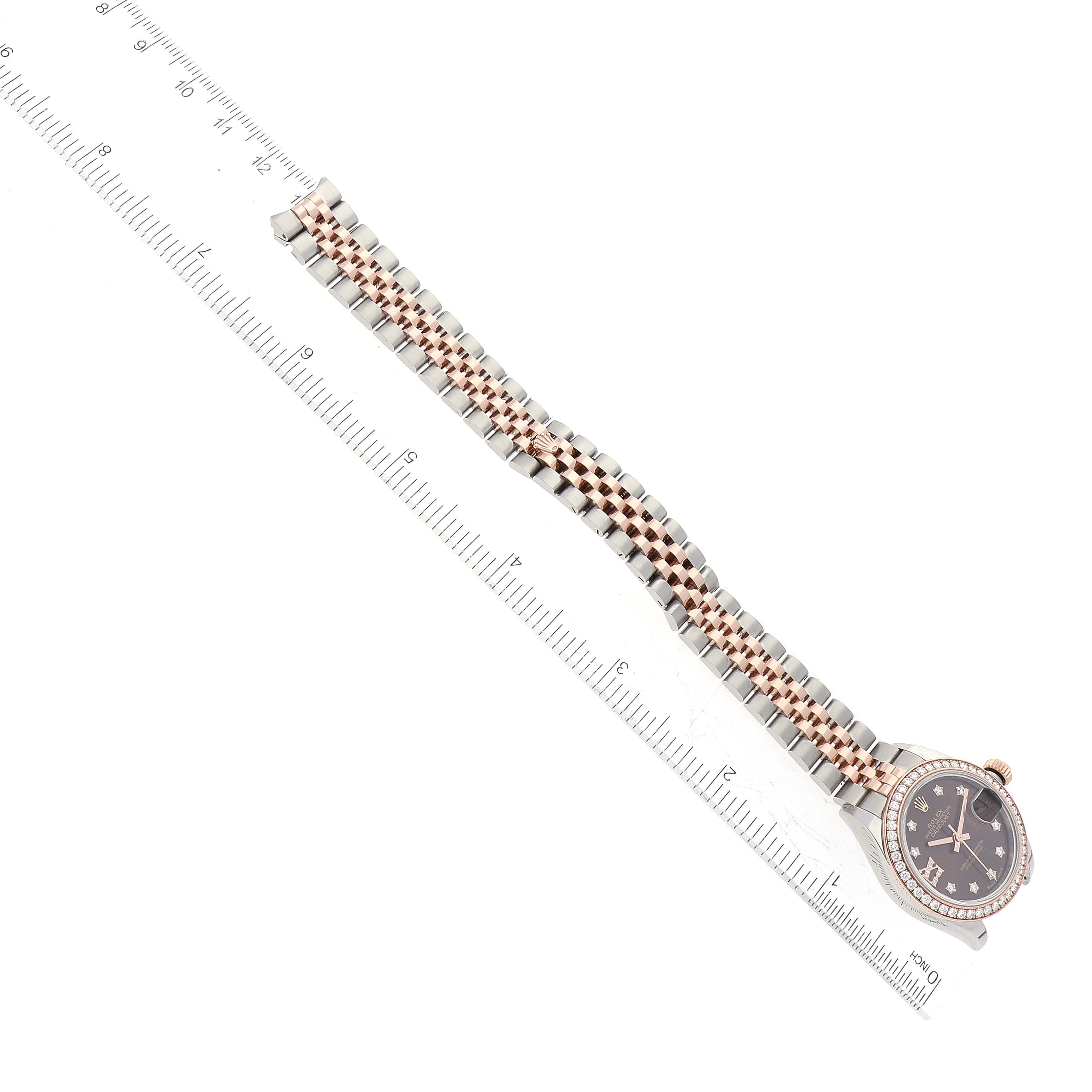 The Rolex Datejust 279381 Women's Steel and Gold (two tone) Brown Dial 279381 Women's Steel and Gold (two tone) Brown Dial watch is shown from a top-down angle with its bracelet laid out alongside a ruler for scale.