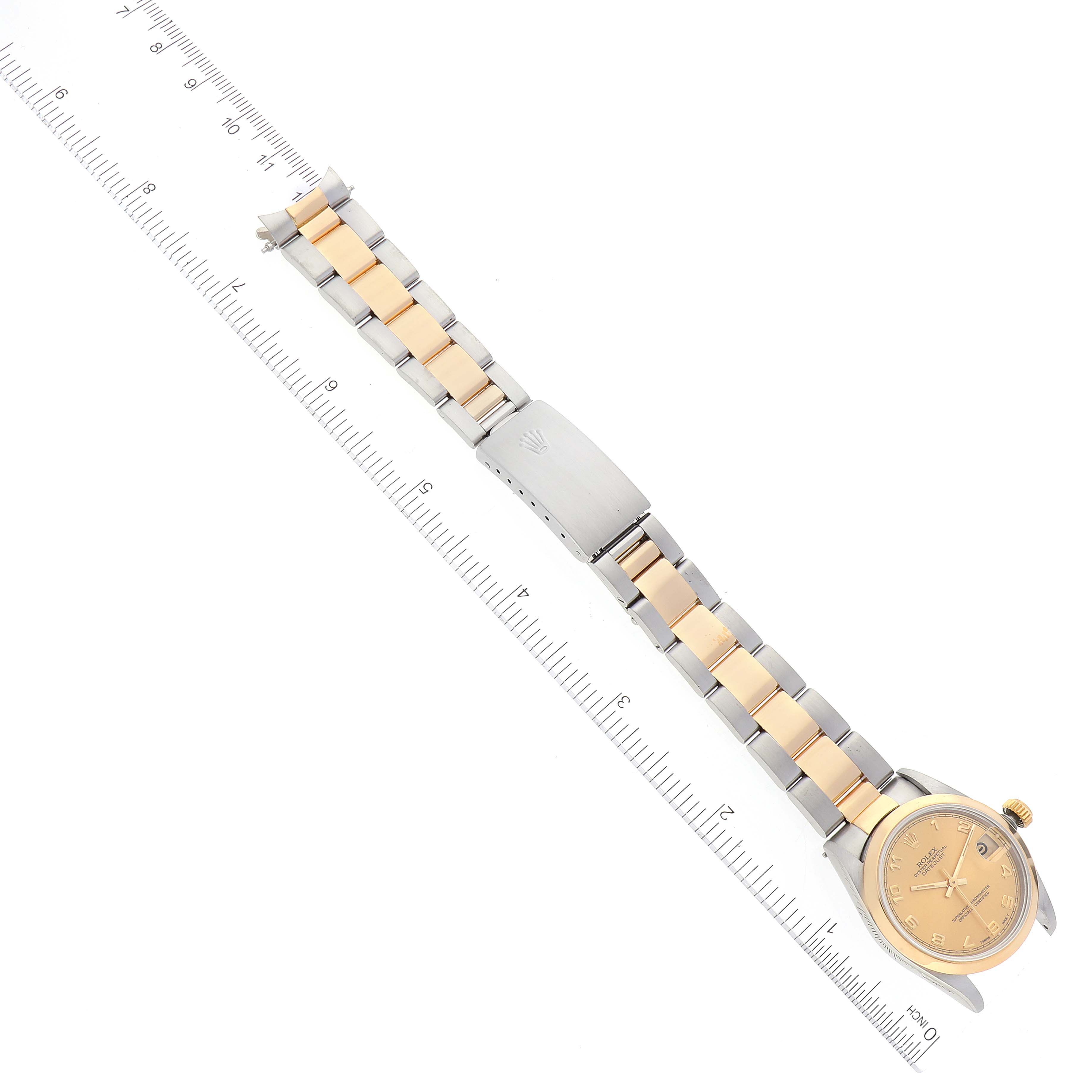 The image shows a Rolex Mid-Size 68243 Women's Steel and Gold (two tone) Champagne Dial 68243 Women's Steel and Gold (two tone) Champagne Dial watch laid flat, displaying its dual-tone metal bracelet and dial, alongside a ruler for scale.