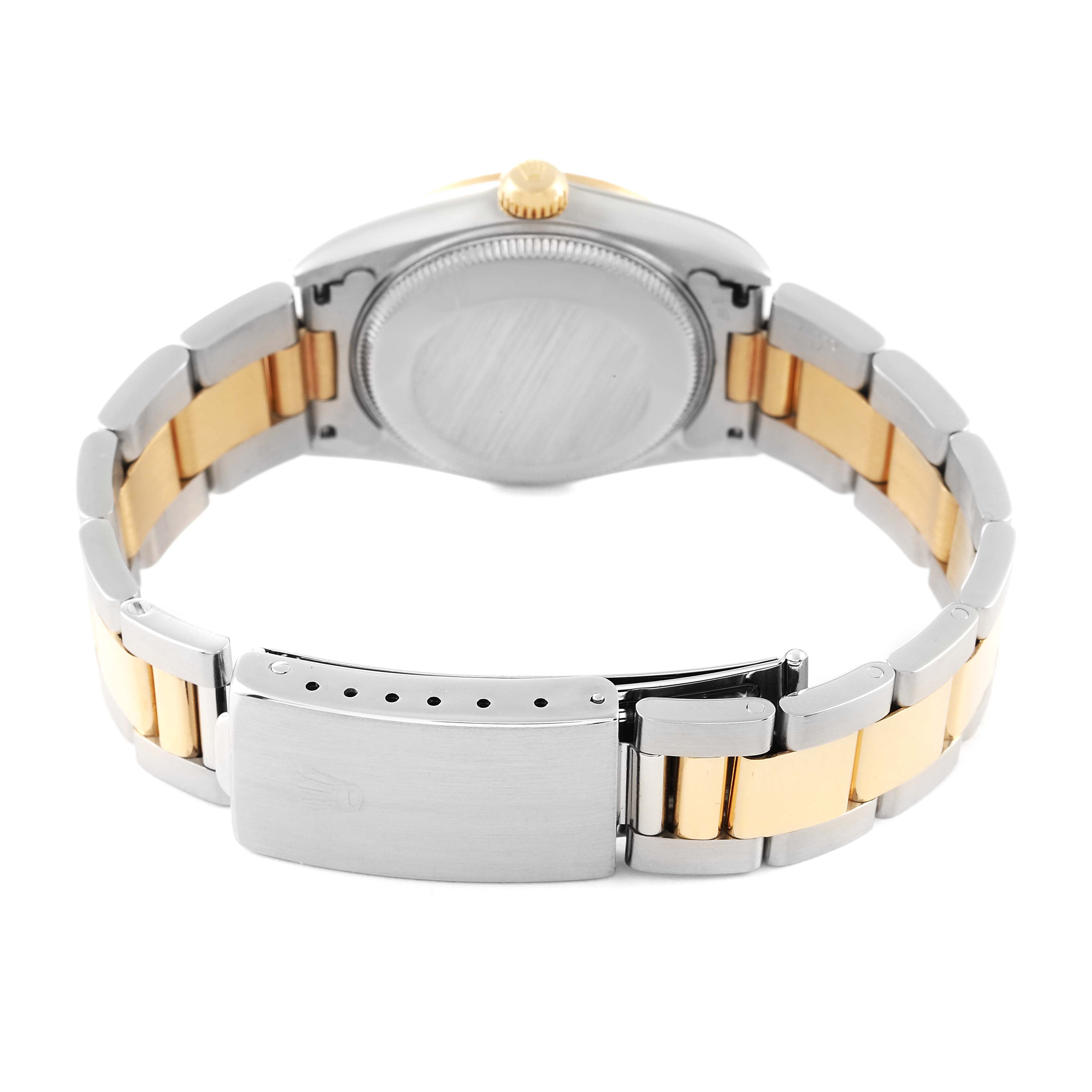 The image shows the rear view of a mid-size Rolex watch, focusing on the clasp and the stainless steel and gold-tone bracelet.
