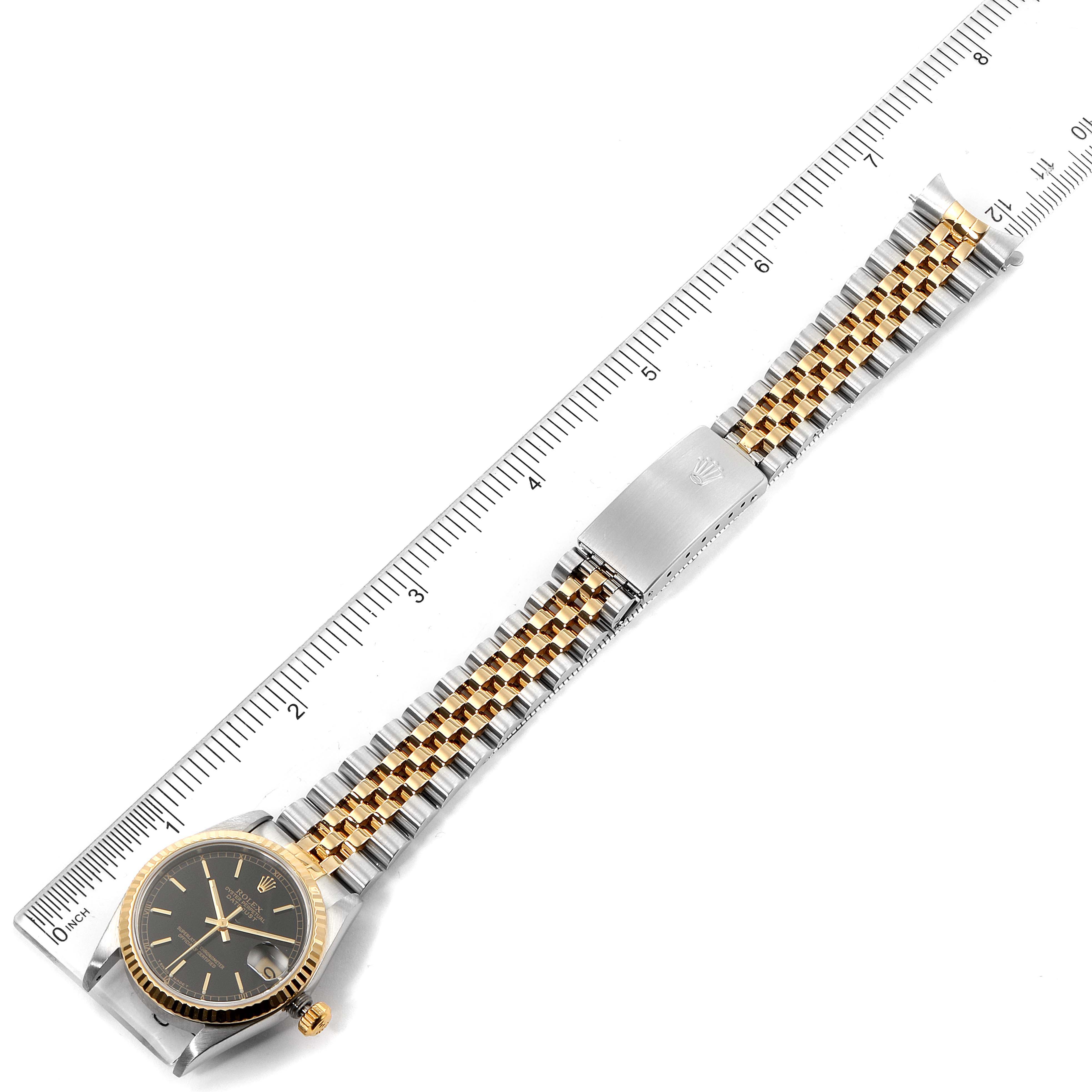 The image shows a Rolex Mid-Size 68273 Women
s Steel and Gold (two tone) Black Dial 68273 Women
s Steel and Gold (two tone) Black Dial model watch laid flat with its face, bracelet, and clasp visible, measured next to a ruler.