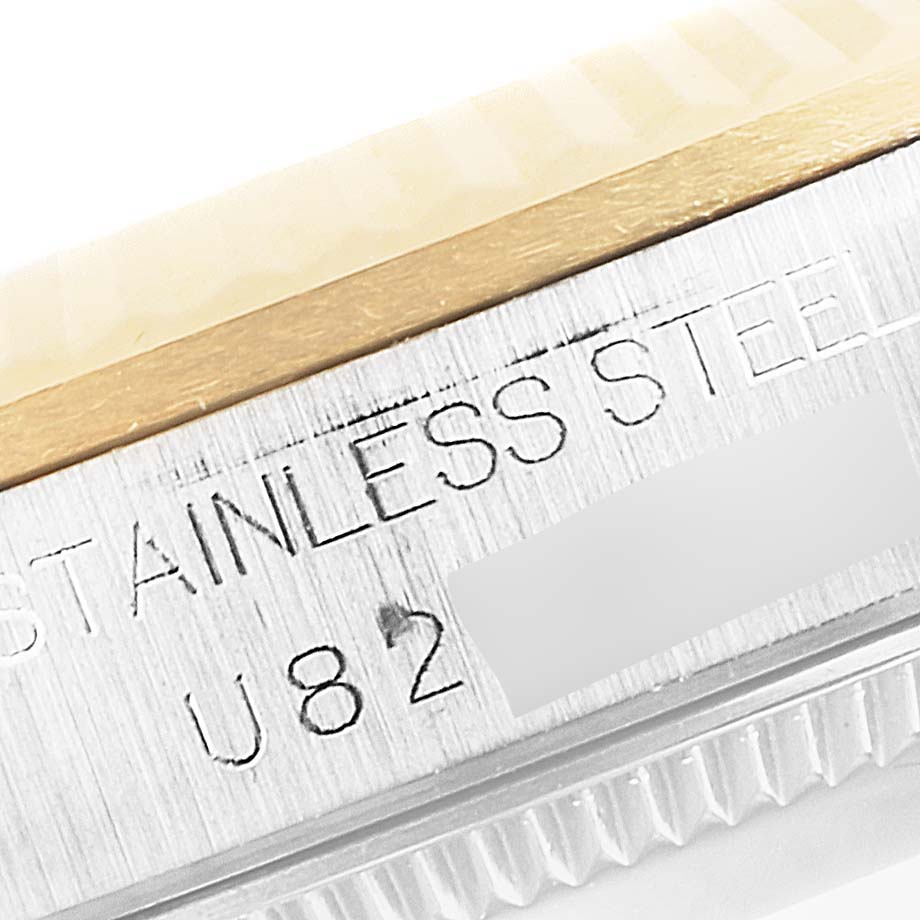 This close-up angle shows the side of a Rolex Mid-Size 68273 Women
s Steel and Gold (two tone) Black Dial 68273 Women
s Steel and Gold (two tone) Black Dial watch, highlighting its "STAINLESS STEEL" engraving and part of the bezel.