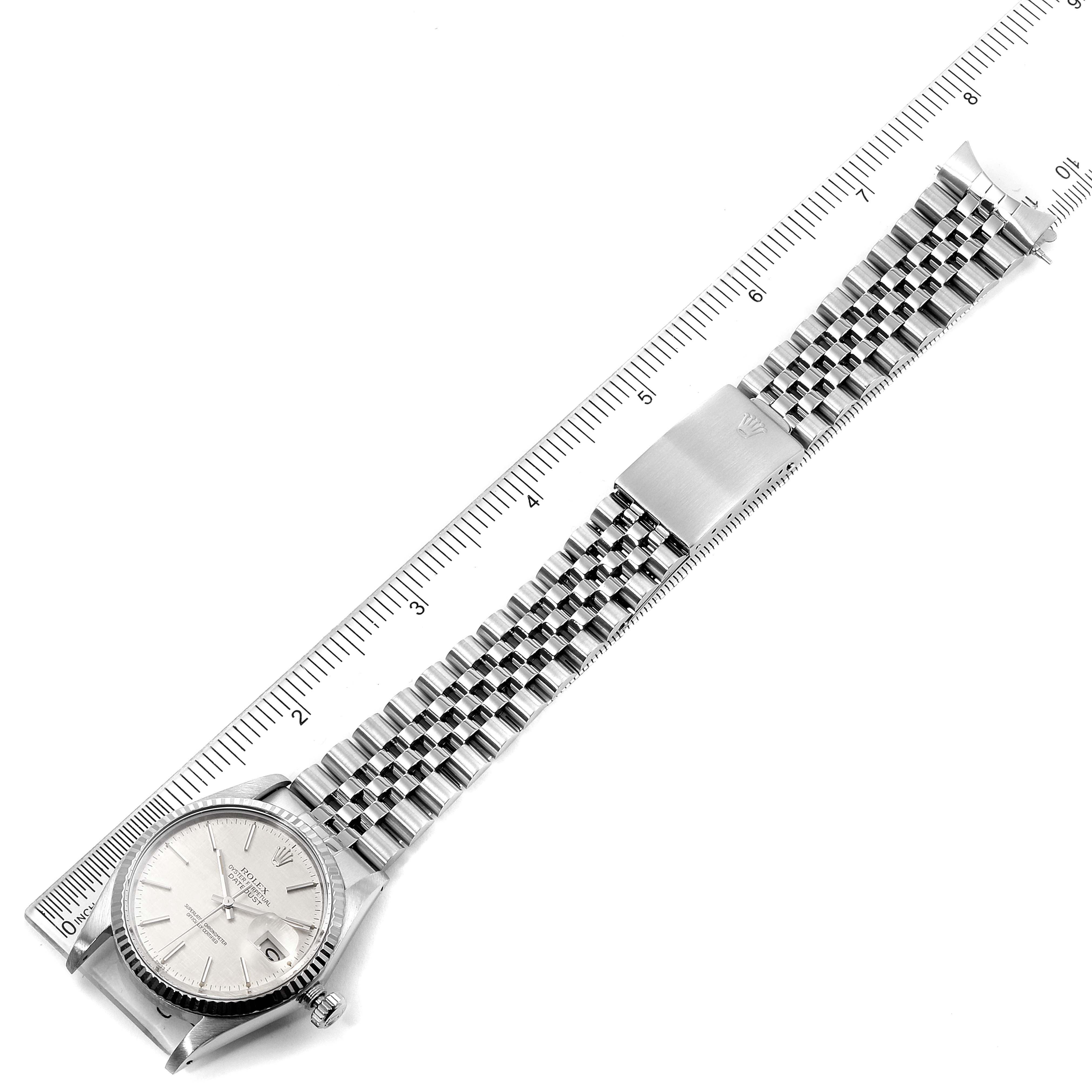 This image shows a top view of a Rolex Datejust 16014 Men
s Stainless Steel Silver Dial 16014 Men
s Stainless Steel Silver Dial watch, displaying the dial, bezel, and metal bracelet next to a ruler.