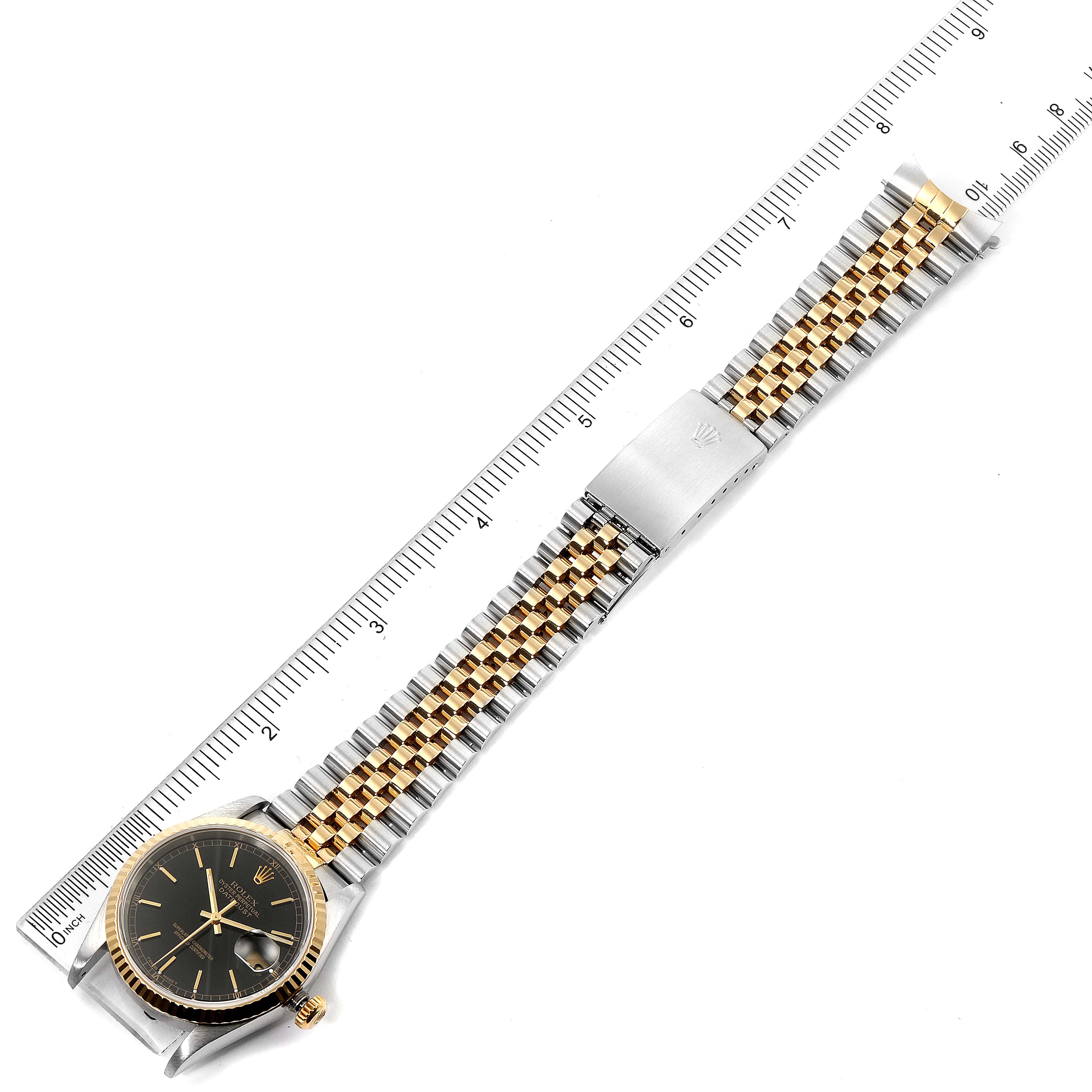 A Rolex Datejust 16233 Men
s Steel and Gold (two tone) Black Dial 16233 Men
s Steel and Gold (two tone) Black Dial watch is shown from a top-down angle, displaying its black dial, gold bezel, and two-tone bracelet.