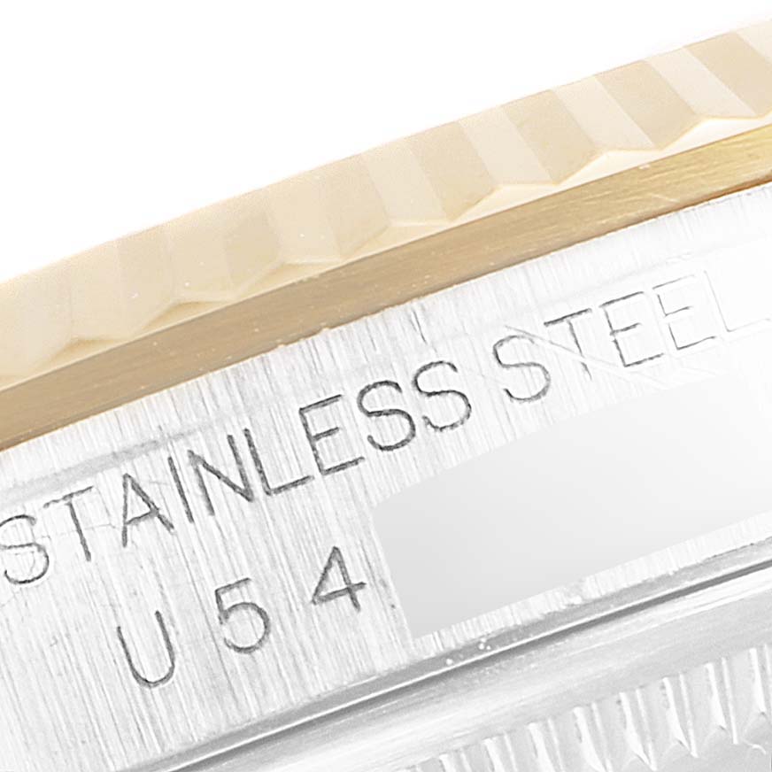 This close-up image of the Rolex Datejust 16233 Men
s Steel and Gold (two tone) Black Dial 16233 Men
s Steel and Gold (two tone) Black Dial model shows part of the fluted bezel and stainless steel case with engraved text.