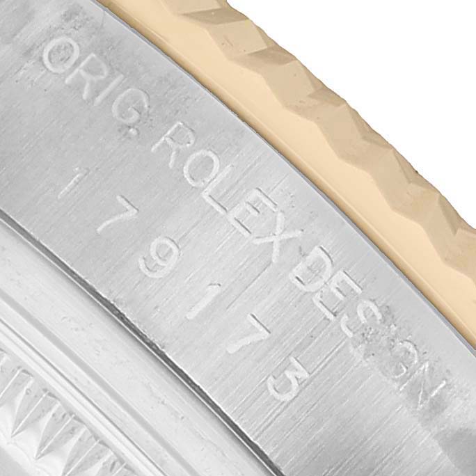 The image shows a close-up of the side of a Rolex Datejust 179173 Women's Steel and Gold (two tone) Champagne Dial, highlighting engravings and part of the bezel.