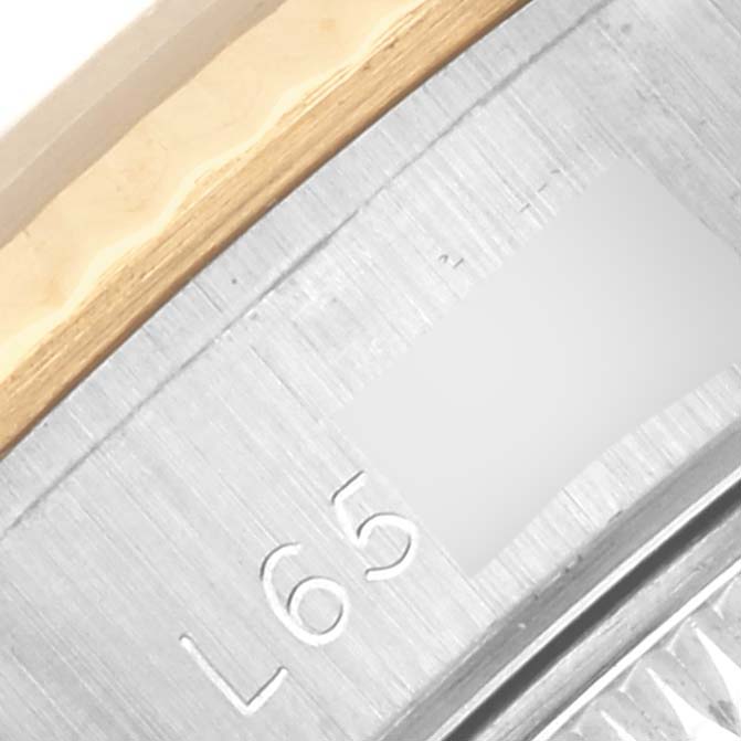 The image shows a close-up angle of the Rolex Datejust 69173 Women's Steel and Gold (two tone) Champagne Dial 69173 Women's Steel and Gold (two tone) Champagne Dial watch showcasing the bezel and part of the case with engravings.