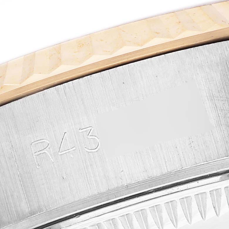 The image shows a close-up of the Rolex Datejust 69173 Women's Steel and Gold (two tone) Champagne Dial model's bezel and edge of the case with engraved markings.
