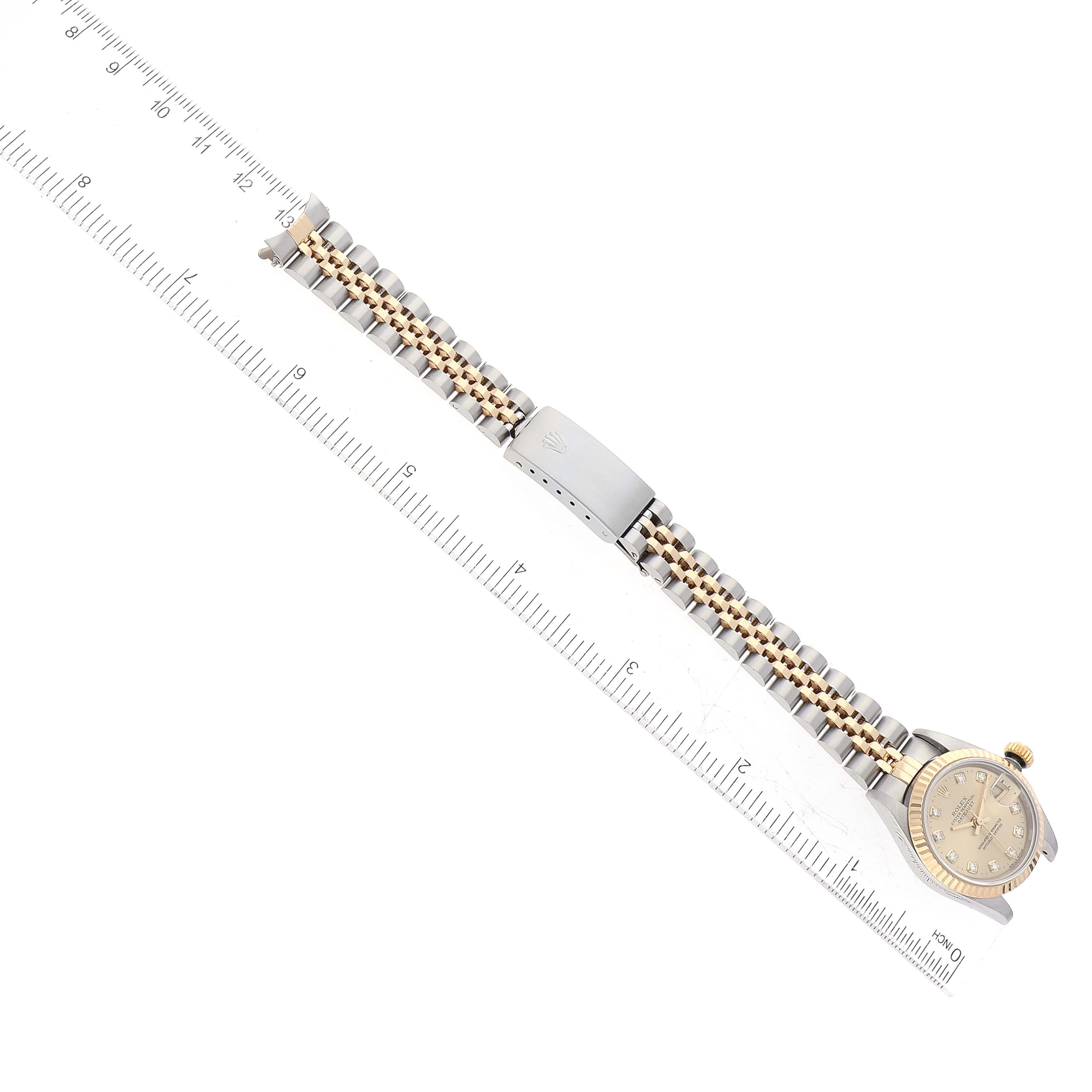 The image shows a Rolex Datejust 69173 Women's Steel and Gold (two tone) Champagne Dial 69173 Women's Steel and Gold (two tone) Champagne Dial watch laid flat with its bracelet fully extended next to a ruler for scale.