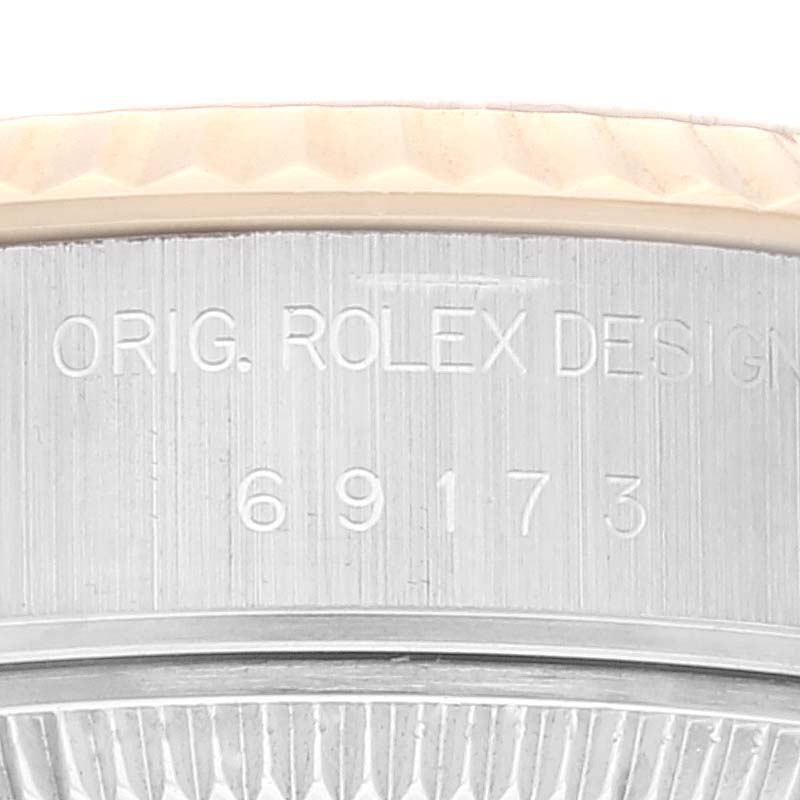 The image shows a macro view of the casing side of a Rolex Datejust 69173 Women's Steel and Gold (two tone) Champagne Dial 69173 Women's Steel and Gold (two tone) Champagne Dial model, highlighting the engraving "ORIG. ROLEX DESIGN" and the serial number.