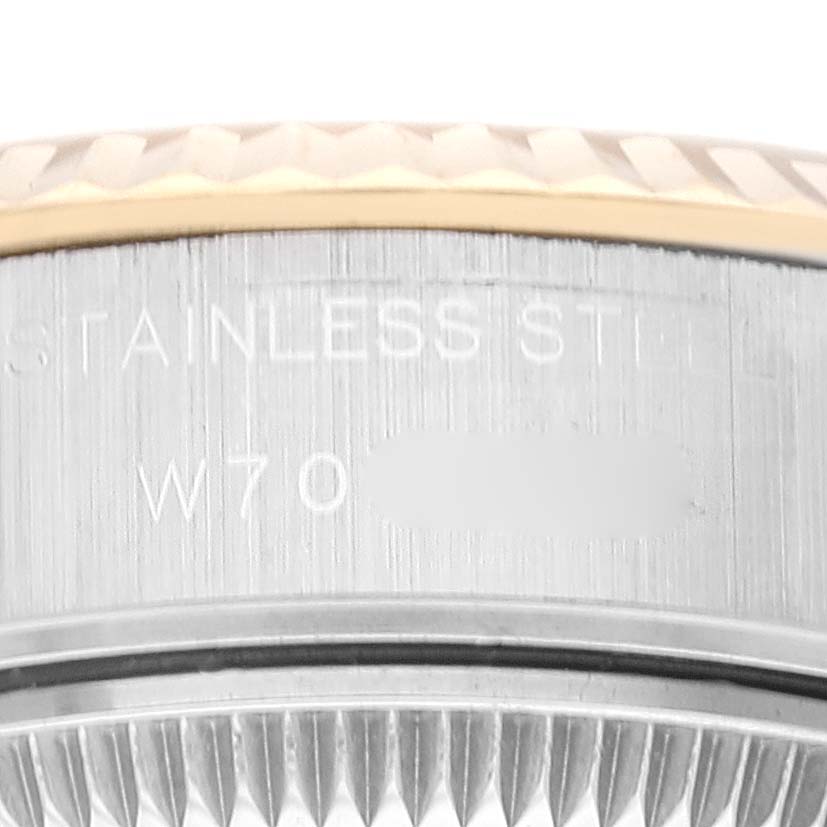 This image shows a close-up of the side engraving on the casing of a Rolex Datejust 69173 Women's Steel and Gold (two tone) Champagne Dial 69173 Women's Steel and Gold (two tone) Champagne Dial watch, including part of the fluted bezel.