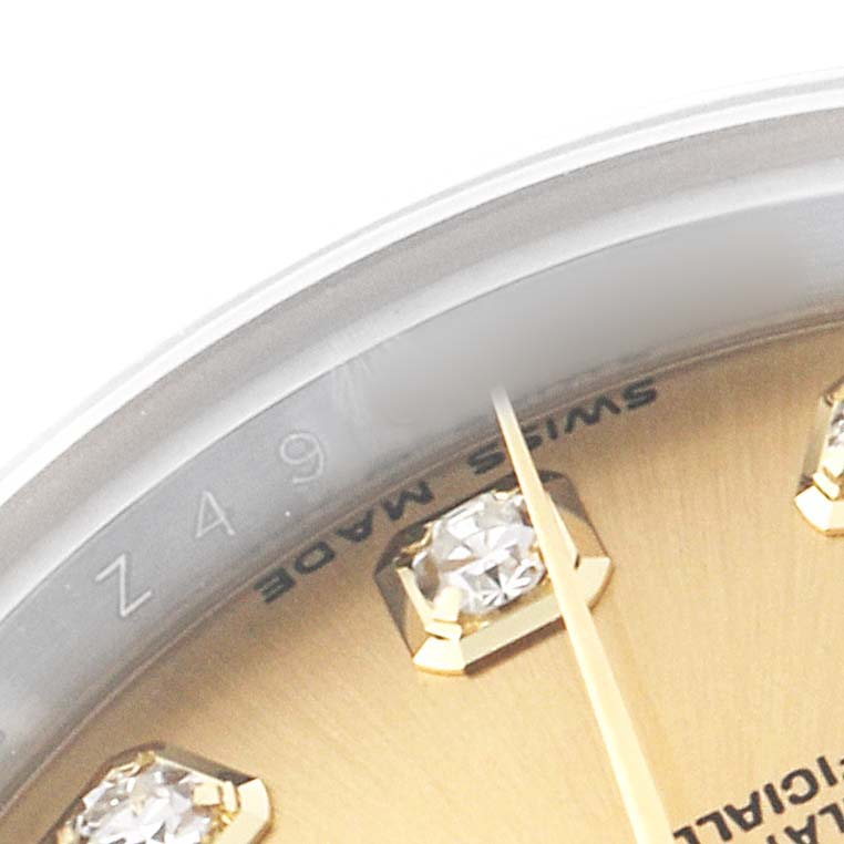 The image shows a close-up angle of a Rolex Datejust 179173 Women's Steel and Gold (two tone) Champagne Dial watch dial with part of the bezel, showcasing a diamond hour marker and "Swiss Made" text.