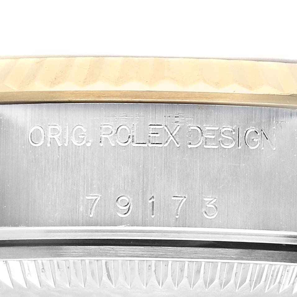 The image shows the side profile of a Rolex Datejust 79173 Women
s Steel and Gold (two tone) Champagne Dial 79173 Women
s Steel and Gold (two tone) Champagne Dial watch, highlighting the serial number and engraved design.