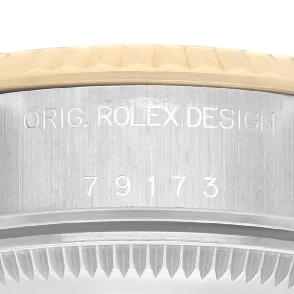 The image shows a close-up of the side of a Rolex Datejust 79173 Women
s Steel and Gold (two tone) Champagne Dial 79173 Women
s Steel and Gold (two tone) Champagne Dial, featuring the bezel and model engraving.