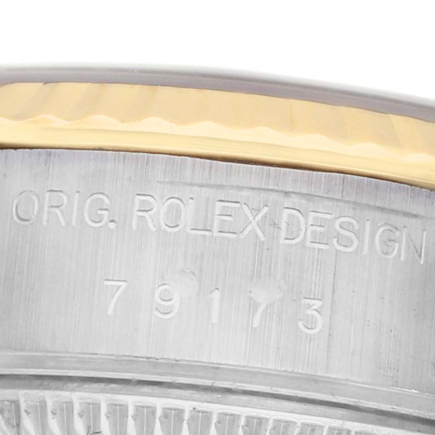 The image shows the side engraving on the case of a Rolex Datejust 79173 Women's Steel and Gold (two tone) Champagne Dial watch, including design and serial details.