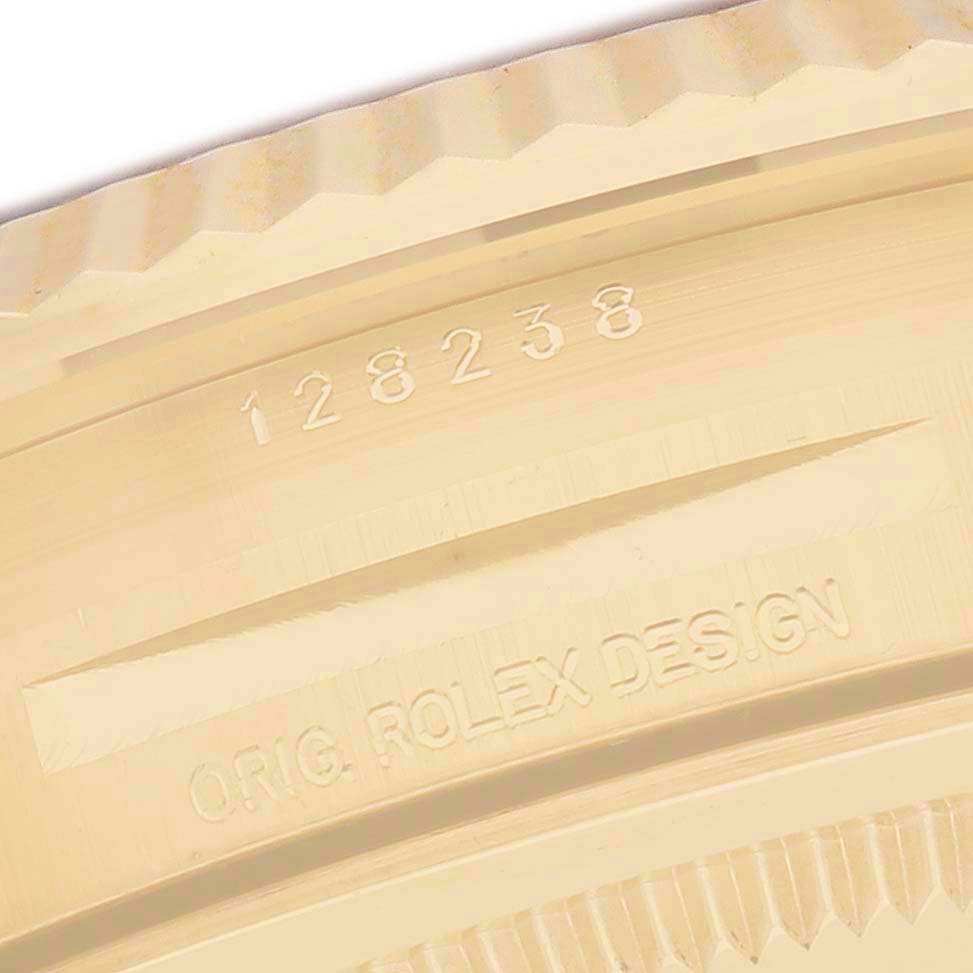 The image shows the edge of a gold-toned bezel from a Rolex President 128238 Men's Yellow Gold Champagne Dial model, displaying the model number and "ORIG. ROLEX DESIGN."