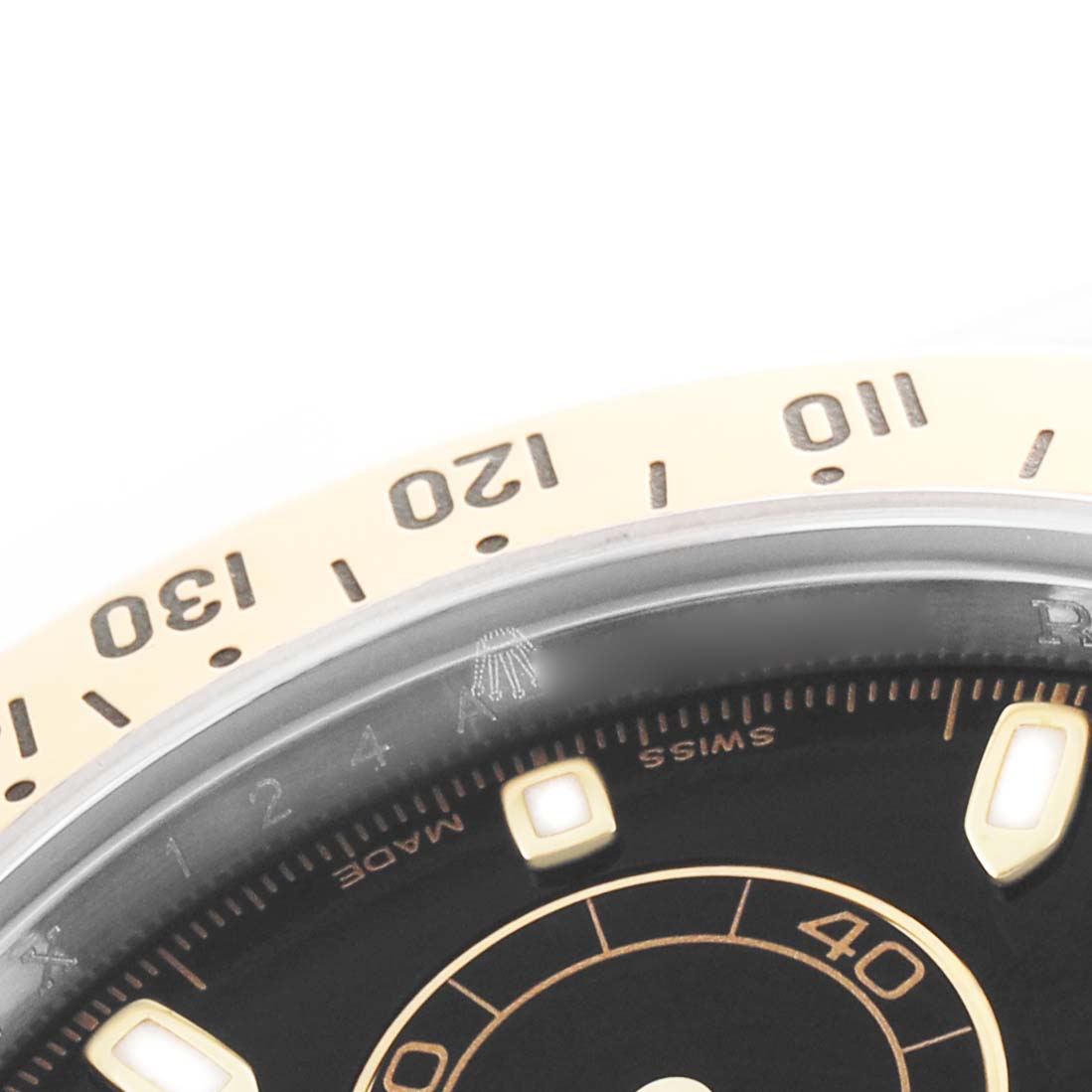 The image shows a close-up of the bezel and dial edge of a Rolex Daytona 116523 Men's Steel and Gold (two tone) Black Dial, highlighting the tachymeter scale and dial markers.
