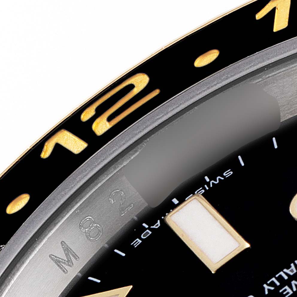 The close-up angle shows the bezel and part of the dial with markings and indices on a Rolex GMT-Master 116713 Men's Steel and Gold (two tone) Black Dial 116713 Men's Steel and Gold (two tone) Black Dial watch.
