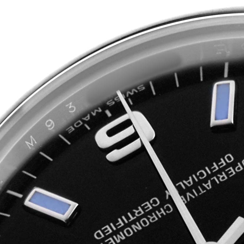 The image shows a close-up of a Mid-Size Rolex watch dial, highlighting the numeral "9" and some hour markers at an angled view.