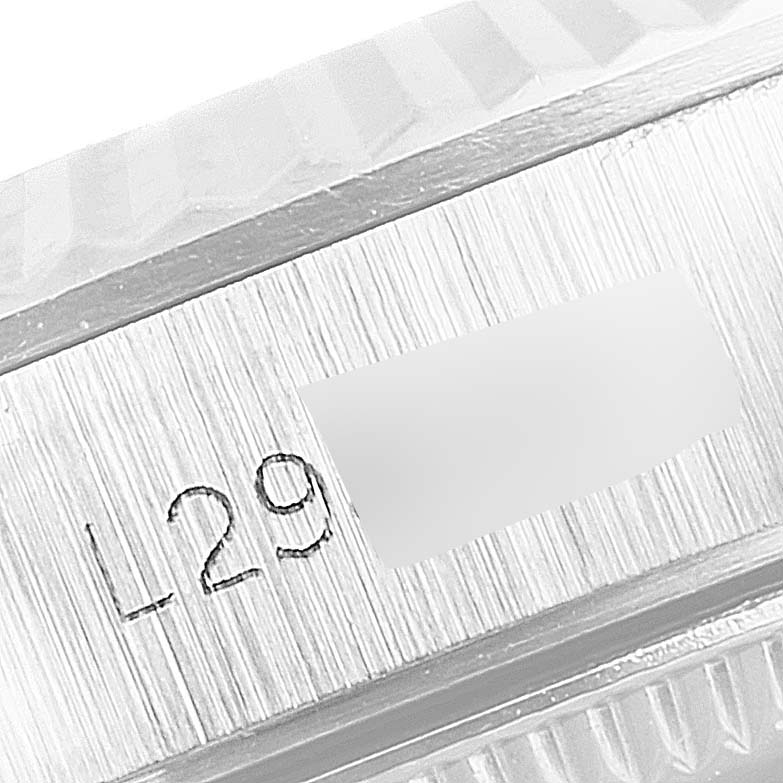 This image shows a close-up of part of the bezel and serial number of a Rolex Oyster Perpetual 67194 Women's Stainless Steel Silver Dial 67194 Women's Stainless Steel Silver Dial watch.