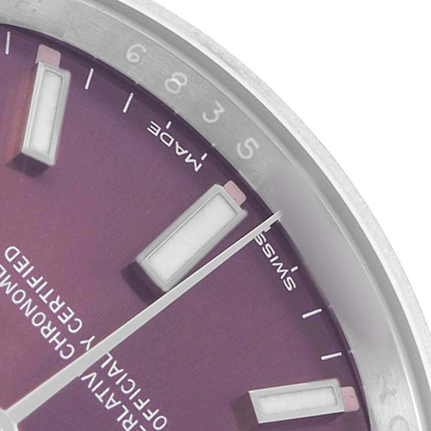 The image shows a close-up of the Rolex Oyster Perpetual 114200 Men's Stainless Steel Purple Dial's dial with hour markers and partial bezel.
