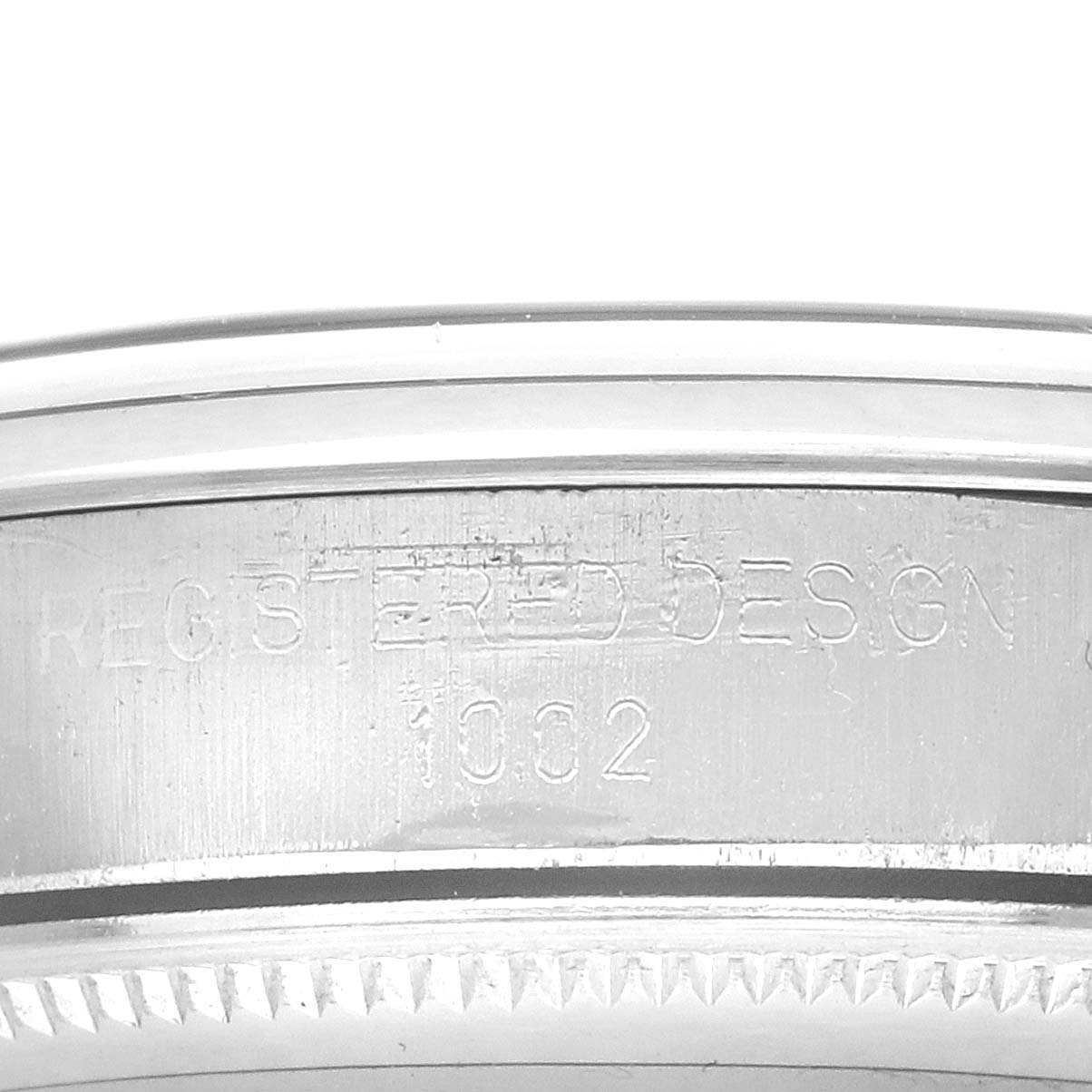The image shows the side view of a Rolex Oyster Perpetual 1002 Men's Stainless Steel Silver Dial, highlighting engraved details on the case.
